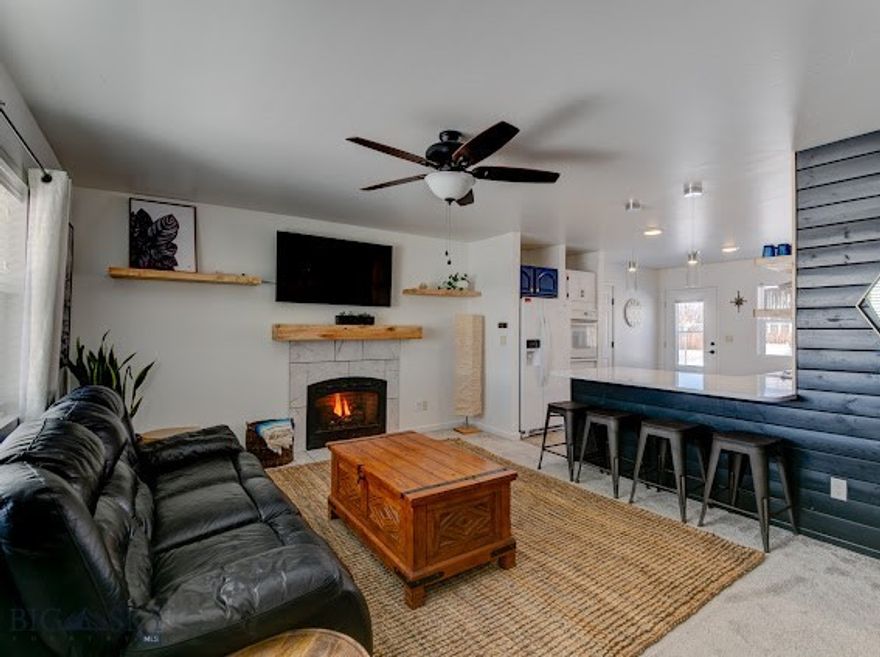 Built in 2020 and located in the scenic Shields Valley, 305 Lathrop St W offers modern construction, efficient single-level living, and the flexibility that buyers are searching for in Montana’s small-town markets. Set on a generous 10,500± square foot lot in the quiet town of Clyde Park, this 2-bedroom, 2-bath home combines low-maintenance living with wide-open valley access just minutes from Livingston. Inside, the home features an open layout with a stylish tongue and groove accent wall, and a cozy gas fireplace that anchors the main living space. The kitchen is designed with everyday function in mind, offering custom open wood shelving, quartz counters, and a layout that flows naturally into the living and dining areas—ideal for both daily living and casual entertaining. Natural light fills the home through large windows, while design touches like a sliding barn door add character and warmth. The single-level floor plan eliminates stairs and crawlspace access, making the home simple to maintain and easy to live in. An attached two-car garage provides excellent storage and parking, and the alley-loaded lot allows for convenient access and easy RV parking. With no HOA or Covenants, city water, private septic, and a manageable lot size, this property offers flexibility for full-time living, rental income, or a lock-and-leave home base. The home has previous success as a cash flowing rental, creating a compelling opportunity for investors or owners seeking additional income. Located near the Shields Valley schools, hospital access, and endless outdoor recreation—from fishing the Yellowstone and Shields Rivers to exploring the Crazy Mountains—this property delivers the balance of modern comfort, rural Montana lifestyle, and practical value that is increasingly hard to find.