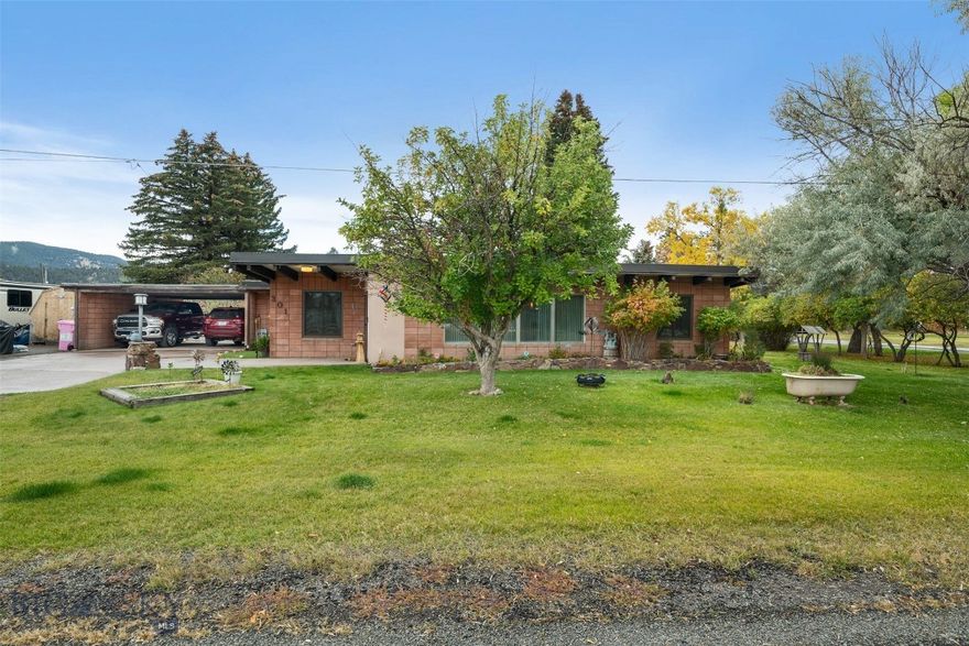 Welcome home to this charming single-level custom residence!
With 4 bedrooms and 2 bathrooms, the thoughtful floor plan offers both spaciousness and comfort. As you step through the front door, you’ll be greeted by a stunning floor-to-ceiling wall of windows and a grand rock fireplace, creating a warm and inviting centerpiece for the living area. The home features both a formal dining room and a sunny breakfast nook, giving you plenty of options for entertaining and everyday living. Two bedrooms and one bathroom are located on each end of the home, providing flexibility for bedrooms, guest quarters, or office space. The utility room includes a laundry area with a wet sink, perfect for handling messy projects and keeping the main living spaces tidy. Outside, the corner lot is beautifully landscaped with mature trees that provide shade and privacy—an ideal setting for outdoor gatherings. A fenced area off the back of the home offers a dedicated space for pets. For those with toys, tools, or trailers, this property truly shines. With generous parking options, a covered carport/breezeway, and a storage shed, there’s room for campers, side-by-sides, and extra vehicles—plenty of space for it all! Call your preferred real estate professional today for your private showing.
