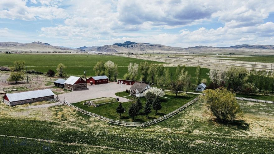 Tucked away along Highway 91 South, this one-of-a-kind property is brimming with character that only time can create. Set against a backdrop of wide-open skies and mountain views, you’ll find yourself sharing the landscape with deer, waterfowl, and the tranquil rhythms of nature.

The grounds surrounding the house and barns are fenced with classic jack leg fencing and dotted with mature fruit and apple trees. A well-manicured yard enhance the charm of the homestead, creating inviting outdoor spaces perfect for relaxing, entertaining, or simply soaking in the peaceful surroundings. Several historic outbuildings, a charming log barn, a sturdy windmill, and a well-preserved root cellar speak to the rich, storied past of this Montana property.

The house itself is a beautiful blend of rustic charm and modern touches. Inside, you’ll find hand-hewn walls, hardwood floors, and a cozy gas fireplace perfect for crisp evenings. The kitchen is finished with granite countertops, and the bathroom features a walk-in tile shower. An enclosed sunroom offers a peaceful spot to relax and take in the surroundings.  

Whether you’re looking for a private homestead, a recreational basecamp, or a sportsman’s getaway, this property lends itself to a variety of uses — including the opportunity to build an additional home. Its timeless appeal and unique features make it a rare find in the Dillon area.