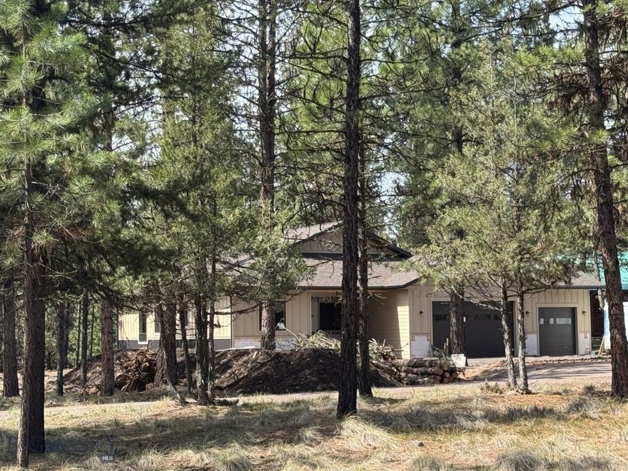 Brand New Custom Home Under Construction - Estimated completion date May 1, 2026. This thoughtfully designed 1,962 sq. ft. single-level home sits on a spacious 1.17-acre lot above the Double Arrow Golf Course. Featuring a bright, open floor plan with abundant natural light, large windows, & 10’ ceilings, this home offers both comfort & style. The living area has a cozy propane fireplace & the kitchen boasts high-end maple cabinetry, granite countertops, a breakfast bar, pantry, & stainless steel appliances. The primary suite is a private retreat with a walk-in tiled shower & glass enclosure, dual vanities, & a large walk-in closet. Two additional bedrooms & a full shared bath provide space for family or guests. Additional highlights include an oversized attached 2-car garage with ATV parking space, a deck/patio for outdoor living, & durable, pre-colored LP SmartSide siding. Conveniently located off a paved road with easy access to Seeley Lake, golf, hunting, & recreational trails.