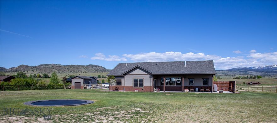 Located in the sought-after Sky View subdivision at the north end of Ennis, MT, this upgraded 4-bedroom, 3-bathroom home offers an ideal blend of modern living and small-town charm. Seller is offering up to $50,000 credit at closing, which may be applied toward a rate buy-down or completing landscaping improvements. Ennis is a welcoming community in Southwest Montana, situated just an hour from Bozeman and Yellowstone National Park, providing access to both outdoor recreation and a peaceful, rural lifestyle.
Built in 2020, this home features approximately 2,596 sq ft (per owner) of well-designed living space on 1.35 acres. It combines high-quality craftsmanship with upgrades that seamlessly blend design and practicality. Inside, the residence offers custom cabinetry and quartz countertops, as well as tiled stone backsplashes. The kitchen is equipped with stainless steel appliances, including a refrigerator, wine fridge, double oven, cooktop, and drawer microwave. The home also includes on-demand hot water, Pella windows, vaulted ceilings with 9-foot walls, and propane forced air heating and air conditioning, ensuring comfort year-round. The propane fireplace adds a cozy touch to the living space, while the primary suite features a double-head tiled shower, makeup vanity, and ample closet space.
Bedrooms three and four share a full-sized bathroom, which features a double sink vanity and a walk-in tiled shower, providing plenty of room and functionality for family or guests. The fourth bedroom includes a Murphy bed, making it a versatile space that can easily adapt to a variety of needs.
Entering from the oversized three-car garage, you’ll find a custom-built laundry room/mudroom that adds both convenience and functionality to the home.
For security, the home is equipped with a system of hardwired Ring cameras and a whole-house water softener and filtration system.
The exterior of the property is just as impressive, offering a large 43x43 concrete slab that is shop-ready. Outdoor amenities include hot tub hookups, an in-ground trampoline, and a half-court basketball area, providing plenty of space for recreational activities. The irrigation system installation has been started and is ready to be finished and connected, offering the opportunity to easily maintain the property’s landscaping. The property also features a 12x12 storage shed and a 1,000-gallon buried propane tank.
