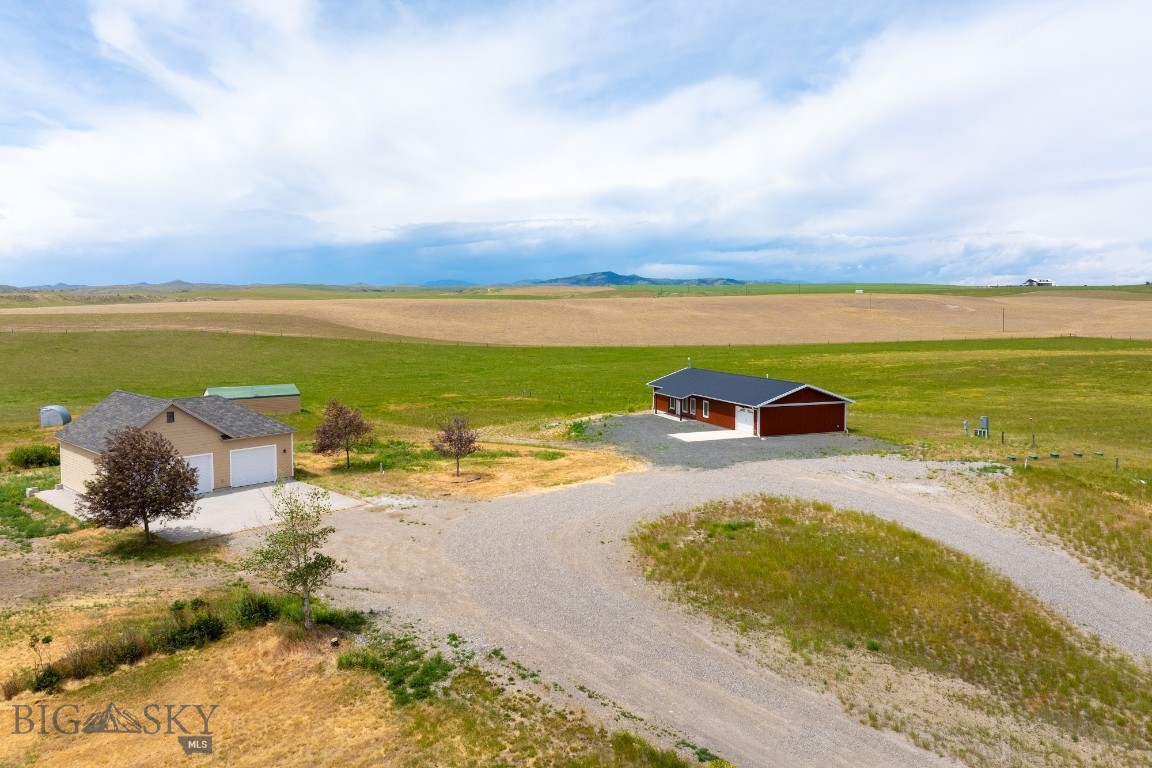 Discover the freedom of country living with this practically new, 2023-built home set on 40 acres of fenced & cross fenced land. Designed with a popular open-concept layout, this single-level 1,600 sq ft home with 2 bedrooms, 2 baths features durable Pergo flooring throughout. Spacious master bedroom has sizeable walk in closet and private bath with a walk in shower. Kitchen has inviting island and plenty of counter space with stainless steel appliances including a brand new gas stove. Laundry area includes a handy utility sink right off garage. Modern low-maintenance metal siding fits perfectly with modern conveniences like air conditioning, a new well, septic system, and a climate-controlled 2 car tandem garage. Plus, you'll love the bonus 38' x 28' detached shop-perfect for projects, storage, or extra workspace. Ready to expand? The property is already set up for future building, with a 400-amp panel and five 1,000-gallon propane tanks in place. An additional large equipment shed adds even more flexibility. Upgrades include a water filtration & security system. Room for horses, cattle, chickens or whatever your dream lifestyle holds. Take in sweeping views of the rolling countryside and distant mountains. Home is part of minor subdivision with minimal covenants and all other parcels are 20 acres. Located just off Hwy 287 N, you're perfectly situated near Three Forks, Bozeman, Butte, Helena and all sorts of outdoor recreation. Covenants and Warranty Deed appear to allow for property to be split into two 20 acre parcels. Buyer to due all their own due diligence. Convenient RV parking with power, water and clean out by garage. Don't miss this great opportunity, call your favorite realtor for a tour today.