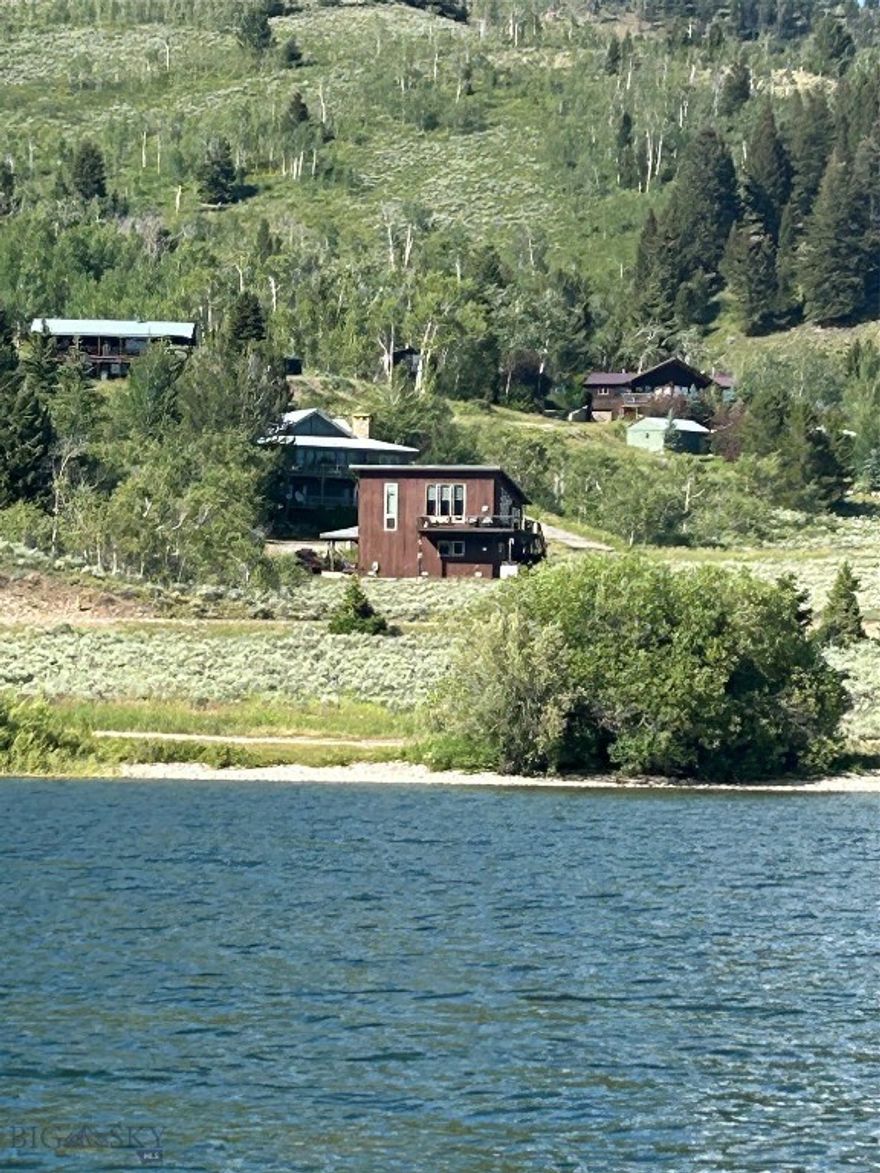 Great opportunity to own a former architect's personal retreat next to Hebgen Lake with trees, terrific views and National Forest land on 2 sides. End of the road location with a protected view of the mountain peaks and Hebgen Lake from both the upper and lower levels. Basically 2 master suites, the lower with additional bunks, laundry and a high efficiency propane fireplace. The upper level has a master suite with a cozy living area, office mezzanine, wrap around kitchen with stone tile counter tops, cherry cabinets, newer upgraded appliances and a convenient breakfast bar also with stone tile.  This home has a great feel with tall ceiling and tall windows to match. The 1812 sq ft home is complimented with a 2nd high-efficiency fireplace, built in ceiling speakers and CAT 5 wiring throughout. All the floors are wood plank or tile, and the home is heated with a high-efficiency propane force air furnace. Added to that you get a heated 2 car garage, a standalone heated office/workshop, making this a great home for any season. Come see the magnificent views and the perfect location of this special property. Call us today to arrange your own private showing, before it's too late.