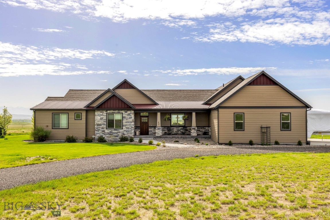 Discover the perfect blend of rustic charm and modern comfort in this spacious 3500+ finished home with breathtaking views of the three mountain ranges just 30 minutes from Bozeman. The thoughtfully designed open floor plan invites comfortable living and effortless entertaining. All 4 bedrooms include a walk-in closet, and the home offers a dedicated office (with closet), a bonus room upstairs, and an oversized laundry room for ultimate functionality. The open kitchen features a extra-large island, copper farmhouse sink, a wet bar, walk-in pantry, and generous dining space—perfect for hosting gatherings. Rich Knotty Alder doors and cabinetry, along with rough-cut wood floors in the kitchen and dining areas, lend warmth and character throughout. Ceilings ranging from 9 to 11 feet enhance the home's expansive feel. Retreat to the primary suite, complete with a private sunroom, two walk-in closets, and large en-suite bath. Cozy up in the living area by the gas fireplace or step outside to relax under the large, covered patio—ideal for enjoying Montana’s summer evenings. An oversized three-car garage includes built-in shelving and a utility sink, and the property offers ample space to add a workshop or barn for horses. Designed with efficiency in mind, the home features multi-zone heating, a heat pump for increased air transfer of cool and warm airflow, two hot water tanks, a fire suppression system, and a lawn sprinkler system. Approx 2 acres with invisible fence. Of the approximately 5600 sq ft footprint, the unfinished 2,000+ sq ft basement is already framed, wired, and rough plumbed for two potential bedrooms, main room and an additional bathroom—offering endless possibilities for customization.
