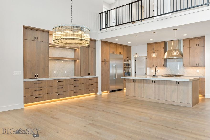 Set on over an acre in Hyalite Ranch, this newly completed custom home by Old Mill Homes was designed for buyers who want clean architecture, meaningful function, and the kind of quality that holds up long after the first showing. With 4,564 square feet, 5 bedrooms, 4 bathrooms, and a 3-car garage, the floor plan delivers what so many luxury homes miss: a large and livable main level, intentional separation between private and shared spaces, and the infrastructure to support real life at a high level.

The main living area opens beneath vaulted ceilings and a dramatic wall of glass, connecting the great room, dining area, and kitchen in a way that feels open without losing warmth. A gas fireplace grounds the room, while mountain views and southern exposure do the rest. Just beyond, a massive covered patio with its own fireplace creates a true extension of the living space, making it easy to enjoy outdoor dining, entertaining, and Montana evenings well beyond summer.

The kitchen is equal parts showpiece and workspace, finished with Thermador appliances, custom cabinetry, generous island space, and subtle details that elevate the experience, including LED under-cabinet lighting and luxury fixtures sourced from Arhaus, Lumens, and Restoration Hardware.

The main-level primary suite is where the house really separates itself. Spacious, private, and beautifully finished, it includes an oversized bath with heated floors, strong scale, and a custom closet that feels intentional rather than an afterthought. Upstairs, additional bedrooms, bathrooms, and flexible bonus space allow for guests, work-from-home needs, recreation, or multigenerational living.

Behind the scenes, the home is exceptionally well equipped with multi-zoned forced air heating and air conditioning, a humidification system, heat recovery ventilation, heated makeup air for balanced ventilation, radon mitigation, upgraded insulation, a whole-house water softener, 400-amp electrical service, wiring for EV charging and a hot tub, and selected windows pre-wired for electric blinds. Even the heated 3-car garage goes beyond storage, with a dedicated dog and boot wash station built for Montana living.

This is a home that delivers the visuals buyers expect, but also the systems, comfort, and long-term quality they rarely find all in one place.  LANDSCAPING INCLUDED WITH PURCHASE.