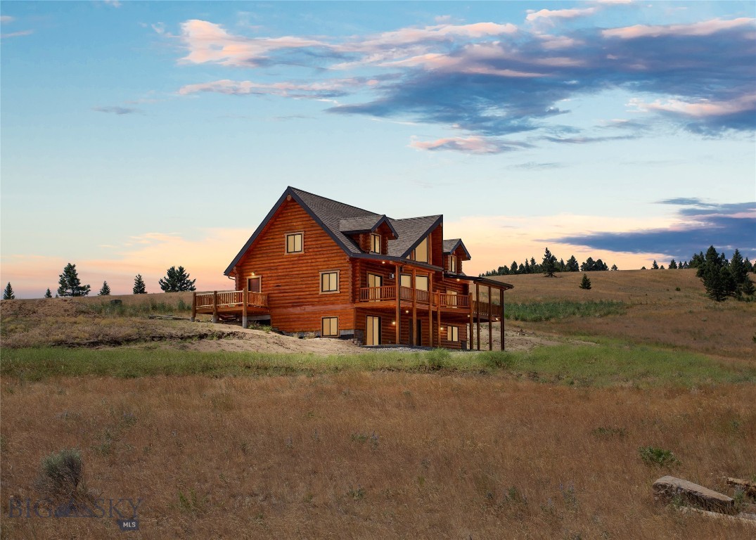 Introducing an exceptional opportunity in Butte, Montana—a stunning, brand-new log home situated on 20 acres. This impressive property features 4 bedrooms, 5.5 bathrooms, and a walk-out basement, meticulously crafted with logs and home plans from Lazarus Log Homes in Whitefish, Montana. Built in 2024 and recently occupied for 2 months, the home and garage are insulated with Corbond for optimal energy efficiency, complemented by sturdy 10-inch logs. The interior showcases a beautiful kitchen and dining area seamlessly integrated with the living space, enhanced by abundant natural light through expansive windows. The main level includes a convenient laundry room and a cozy gas fireplace. A triple car finished garage with a 25-foot apron offers extensive storage and parking. Additionally, a 30'x40' Corbond-insulated shop with 3 overhead doors and a service door awaits, perfect for storing Montana toys. Landscaping, including a stamped concrete patio on the north-facing front side, is scheduled to commence soon. The basement is designed for flexible living, featuring plumbing for a kitchen, air conditioning, a heater, and an on-demand hot water tank. The property benefits from a productive well yielding 25 gallons per minute with a 60-gallon pressure tank, supplemented by an owned underground 1000-gallon propane tank. An annual HOA fee of $400 covers road maintenance, ensuring year-round accessibility. Located just minutes from town, this property offers frequent wildlife sightings, including moose, deer, and elk, visible from the spacious deck and patio. Its proximity to State and BLM lands provides endless recreational opportunities. Whether you're entertaining guests or seeking tranquility amidst nature, this meticulously designed home offers the perfect backdrop for your Montana lifestyle.