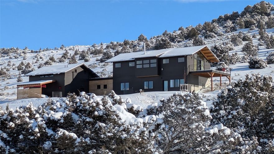 Welcome to Solstice House!  Built in 2022, this architectural home offers 2,705 square-feet with an ADU, and it's well placed on 20+ acres with ample room for a guest house, a barn or shop, pasture, and more.  This home was designed in the style of Northwest Modernism, popular since the midcentury for its floor-to-ceiling windows, connection to the outdoors, high livability, natural materials, and clean lines.  The design is also on the mark for 2026's trend of "quiet luxury," emphasizing smaller, high-end homes with meaningful features and understated comfort.

Three bedrooms and two baths with 9' ceilings comprise the ground level, while the pavilion-like upper level presents a grand living area with 360-degree views and a vaulted ceiling.  The primary architectural gesture is the alignment of the great room with sunrise on the summer solstice, giving the house its name.  With a large deck and patio to elevate the indoor/outdoor experience, horses grazing in the surrounding hills, buttes and ridges replete with wildlife, Big Sky sunsets, it's a tranquil place where evenings feel like weekends and weekends feel like escapes.  

In support of the primary home, there's an ADU with a private entrance, covered parking for a drift boat or small camper, the well log records an astounding 100 gallons per minute, and the setting offers outdoor access in every direction.  Located in Gallatin River Ranch, the vast 6,000-acre development is lifestyle-enhancing with two famous rivers, an impressive Equestrian Center, two riverside parks, and over 20 miles of private roads and trails great for hiking and biking.  Less than three miles from charming Manhattan, Mont., Solstice House is a 20-minute drive from the airport and 30 minutes to Bozeman's growing amenities.