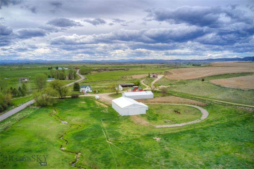 Located just 6 miles north of Belgrade and 20 minutes from Bozeman, this 29± acre property offers two homes, two barns, live water, fenced pastures, and multiple outbuildings. With income potential and an excellent site to build your dream home, this property is a rare opportunity in the Gallatin Valley. This versatile and well-maintained property offers rare space and opportunity so close to town—an inviting retreat with room to grow, farm, or simply enjoy Montana living at its best. NO ZONING. NO COVENANTS.