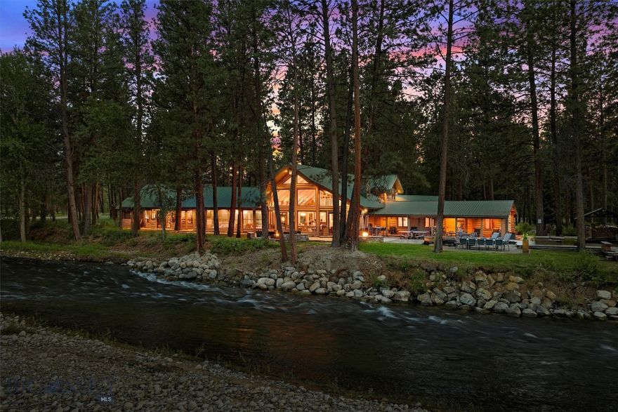 Set on nearly 22 acres with almost 2000 ft of prime Bitterroot River frontage, this unique Hamilton, Montana property features a rare combination of river access and high-end accommodations. At the heart of the property stands a stunning log home lodge, showcasing classic Montana style and craftsmanship throughout. Inside, you’ll find attractive hardwood flooring, a beautiful river rock fireplace in the main common area, and a warm, inviting atmosphere that blends comfort and quality. The lodge includes three guest suites plus a deluxe primary suite, each room thoughtfully and stylishly appointed to provide rugged-yet-refined Montana character. Beyond the main lodge, the property features two well-designed cabins, a barn with apartment, and three luxury glamping huts, each one echoing the same attention to detail and rustic comfort found throughout. The entire property is being offered fully turnkey, including furnishings and equipment. 

Generous windows throughout the lodge bring in plenty of natural light and frame stunning views of the Bitterroot River, just steps from the back door. The spacious kitchen is designed to handle everything from casual meals to full-scale entertaining. High-end appliances, dual sinks, and ample cabinetry make it both functional and efficient, while attractive quartz countertops offer plenty of room for food prep and serving. A spacious dining area with a bar and TV creates the perfect gathering space for entertaining, relaxing after a day on the river, or hosting guests. With a total of 10 bedrooms with 15 beds, 9 bathrooms, and 9,284 square feet of finished space, this property provides options for a variety of uses. With nearly a third of a mile of Bitterroot River frontage, you’ll have front-row access to some of Montana’s best fly fishing, along with incredible views and a deep sense of privacy just minutes from downtown Hamilton.