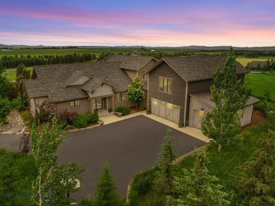 Experience Montana luxury in this beautiful custom Locati-designed residence, perfectly positioned on one acre within the exclusive Green Hills Ranch subdivision. Enjoy sweeping views from the moment you enter the home through the striking glass front entry door. This stunning residence borders open space and overlooks conserved farmland showcasing impressive views throughout the home. Features include four bedrooms, each with an en-suite bathroom, a dedicated theater room, home office, powder room and an impressive five-car garage. Additional amenities include the spacious main floor primary suite with walk out patio, an underground dog fence, and surround sound throughout the home and covered patio. Both indoor and outdoor natural stone fireplaces create the perfect gathering spots, while custom finishes like reclaimed corral board ceilings and French oak flooring add to the charm. The home's thoughtful design maximizes the incredible views through the expansive windows. You'll love entertaining in the spacious gourmet kitchen featuring an oversized quartz island and high-end appliances. Custom finishes throughout create an atmosphere of refined elegance. The well-designed layout flows seamlessly from room to room, maximizing both functionality and style. Green Hills Ranch offers a unique Montana lifestyle with dedicated open space and trails. This community sits at the foothills of the Gallatin Range, nestled in a pastoral setting with rolling meadows and open fields. The desirable location provides easy access to outdoor recreation while maintaining close proximity to Bozeman's vibrant dining and shopping scene. This home perfectly combines luxury living with Montana's outdoor lifestyle, offering both privacy and convenience in one of the area's most desirable communities.