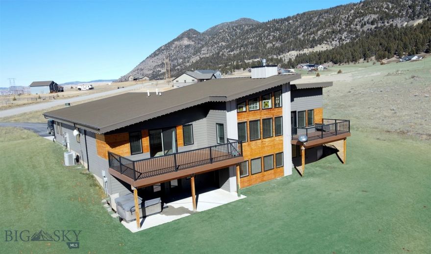 Nestled on 2.7+ acres in sought after south Butte, this exceptional property captures the ideal balance of privacy, sweeping views, and convenience to town. Thoughtfully designed and beautifully finished, the home is south-facing filling the living areas with natural sunlight and warmth.   The main floor showcases an open-concept floorplan, seamlessly connecting the kitchen, dining, and living room. Large windows, cathedral ceilings and a cozy gas fireplace enhance the sense of space and inviting feel of home.  The kitchen includes a spacious island for gathering and meal prep, along with a large walk-in pantry.  The main floor primary suite offers a private retreat, complete with a stunning spa-inspired bathroom featuring a soaking tub, tiled walk in shower, and dual sinks. A well-placed half bath near the kitchen, along with a mudroom off the attached garage, enhances the functionality and convenience of the main floor.  Patio doors from both the living area and the primary suite open to spacious decks, ideal for relaxing or entertaining while taking in the serene surrounding landscape.  The walk-out basement extends the living space with a comfortable family room, four additional bedrooms, and two full bathrooms - the bedrooms can also function as an office if desired – and a laundry room.  Other mechanical features include air-conditioning, tankless water heaters for hot water on demand,  a community sewer system, and the property is serviced by natural gas.  With excellent road access, a peaceful setting, and plenty of room to spread out, this property delivers the comfort of rural living just minutes from town.