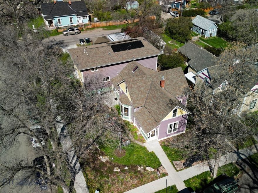 Opportunity knocks - This unique and high performing triplex offers a trifecta of built-in value: a historic footprint, a proven income stream for over 25 years and a coveted location in the heart of historic Bozeman. First time on market in over 25 years! Situated just blocks from Main Street shopping, dining and amenities and minutes to Montana State University, this property is the perfect blend of location and lucrative investment potential. Fully rented and priced to sell at a 5.8% cap rate, the property consists of three intentionally built units. The front unit is a charming Queen Anne style two story home – known as the Susan Kirk Residence. Featuring up to 5 beds: 4 conventional beds plus a walk-through flex/office and two baths. The main floor features spacious living areas, kitchen and bath. The home has been well maintained and includes a side driveway for parking, enclosed front and rear entryways and retains its historic charm with colorful paint and gingerbread elements including scalloped shingles and a variety of exterior siding textures. An attached duplex features Piping Plovers from the Craigshead Institute’s Murals of threatened and Endangered Species Project. The duplex consists of two side by side units, each with 5 bedrooms and 2.5 bathrooms, featuring spacious living and kitchen areas and additional flex space. An expandable rooftop solar array is connected to the north duplex unit and features EV charging. Concrete parking area features parking for 4 vehicles. A 2-car detached garage is currently used by the owners includes space for a shop/storage. There are several communal bike storage areas on the property including a covered pavilion. Yard spaces have been improved with thoughtful native landscaping and raised garden planters for the occupants to enjoy. Mature trees and shrubs allow for privacy and shade in summer. Many possibilities exist to make the property your own (maintain/condex/development). This is a wonderfully convenient southside Bozeman location – only minutes to Montana State University, hospital, shopping, breweries, music venues, grocery stores, restaurants, services and amenities. Only 25 minutes to Bridger Bowl, 30 minutes to blue ribbon fly-fishing and river recreation, and 1 hour to Big Sky.  Please don’t disturb the tenants – shown by advanced appointment only.  Don’t miss the VR Matterport Tour.