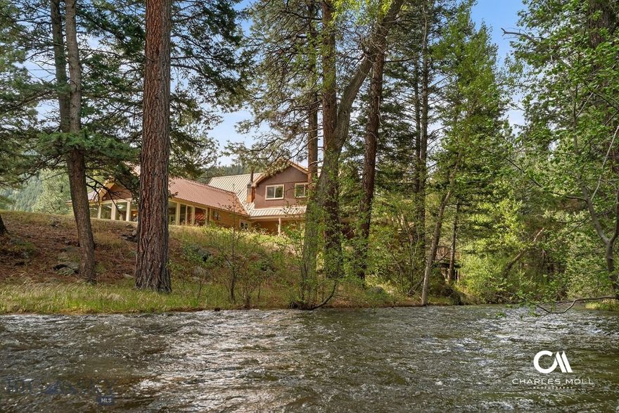 Just imagine crossing the creek on your driveway bridge to reach your charming creekside oasis nestled in the trees on a lush 3.87 acre lot. Fish right off your deck or just relax and enjoy the soothing sounds of the year round creek running just out your backdoor from any window in the home.  This oasis is conveniently just 15 minutes from Downtown Helena and under a mile from the state hwy for great year round access. Enjoy the feel of mountain living, without the long drive or 4x4 required. The original A-frame cabin has been transformed over the years into a spacious 3-bedroom, 2-bath home. The main level bedroom offers a bonus room with its own access to the creekside. A vaulted ceiling great room is warned by a propane stove and opens on to the spacious creekside deck. The kitchen/dining room includes a charming stone fireplace for fireside dining. The sunroom off the kitchen is the perfect place to take in your scenic property and it overlooks the private footbridge over the creek.  Recent updates include a new metal roof and a solar system providing huge utility savings. The attached 2-car garage includes additional shop space complete with a wood stove, ideal for hobbies or storage.  
This property combines a dream location & unbelievable outdoor living space with a spacious warm home that still retains some of the historic mid-century charm. This home feels like bring at summer camp year round! This unique property has no covenants and the opportunities are endless. Bring the animals, build a shop, add an ADU, make it a stunning vacation rental retreat, whatever your heart desires.