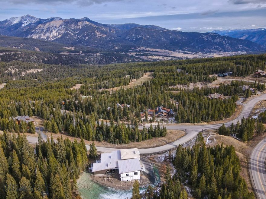 Set amidst the grandeur of Big Sky’s Spanish Peaks Mountain Club, this extraordinary home is a modern mountain sanctuary where architecture and landscape live in perfect harmony. From the moment you step inside, walls of floor-to-ceiling windows frame sweeping, unobstructed views of the Spanish Peaks mountain range, flooding each room with golden Montana light and an ever-changing panorama of alpine beauty.

Designed for both relaxation and recreation, the residence features five spacious bedrooms and six and a half baths, offering luxurious comfort for family and guests alike. The heart of the home is a grand great room anchored by a handcrafted stone fireplace, where evenings unfold in warmth and style. The wine room, with its 17-foot ceilings, creates a signature space just off the great room, while the indoor sauna provides the perfect retreat after a day of skiing or hiking.

For those with an active spirit, there is a private sport court designed and built for regulation pickleball along with a basketball hoop, hockey nets or workout area -  opportunities abound for your needs. The trail system is just steps from the back door and offer endless choices for play and exploration. Enjoy the Tom Weiskopf golf course or the Tom’s 10 Par 3 Course. The Spanish Peaks Club house offers fine dining, clubhouse bar, golf/ski shop, fitness center and pool/hot tub. Expansive outdoor living spaces — including a large patio with kitchen out back and a covered deck out front — create an effortless flow between the indoors and Montana’s magnificent outdoors.

Only a short drive from Big Sky’s Town Center, this residence combines refined design, thoughtful amenities, and a deep connection to nature. It’s more than a home — it’s a lifestyle defined by serenity, adventure, and the unmatched beauty of the Spanish Peaks. Scheduled completion spring 2026.