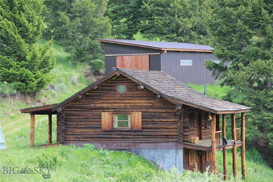 BORDERS FOREST SERVICE
Set above Ferrell Lake in the quiet Grizzly Meadows area, this log home offers the best of Montana self-sufficiency, and connection to nature. Built in 1999 and resting on 20+/- acres, the property offers unique value in self-sustainability as it is 100% powered by wind and solar energy. 
The 1,612-square-foot layout (not including loft) includes one bedroom and one full bathroom, with both front and back porches framing sweeping panoramic views of the Gallatin Mountains. A year-round creek meanders through the lower portion of the acreage, forming a natural wildlife corridor frequented by moose, bear, elk, deer and all other seasonal wildlife migrating from Yellowstone National Park whose grand entrance through the Roosevelt Arch is just 30 minutes away.
With approximately 2,000 feet bordering Forest Service land, the property offers immediate access to public Forest Service, ideal for hiking, hunting, and opportunities to get in touch with nature. An 800-square-foot metal-sided pole barn, constructed in 2009, adds practical utility for vehicle storage or equipment needs.
When you are in need of shopping or a night out, Emigrant lies just 40 minutes away where you will find Chico Hot Springs, fine dining at Sage Lodge, and lively summer concerts at the historic Old Saloon. Gardiner offers additional shopping, dining and opportunities for adventure at Yellowstone Raft Company, Montana Whitewater, and Flying Pig Adventures. Livingston with its cultural appeal is approximately an hour away while the trip to Bozeman will take 90 minutes. For those drawn to the quiet calm environment of solitude and self-sufficiency, this property offers rare opportunity for energy independence, unfiltered beauty, and proximity to one of the most iconic landscapes in the American West.