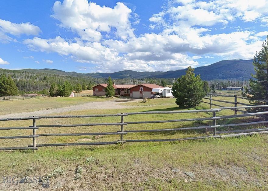 Situated on 8.28 acres of scenic Montana countryside, this exceptional property at 240 Roosevelt Drive offers the perfect blend of space, comfort, and functionality. With breathtaking views of the surrounding mountains and valley, this home is ideal for those seeking privacy, room to roam, and a true Big Sky lifestyle.
The spacious residence features 4 bedrooms and 2 bathrooms, including three bedrooms and a full bath on the main level. An updated kitchen serves as the heart of the home, offering modern touches while maintaining a warm, inviting feel. Step outside onto the expansive wrap-around deck and take in the stunning panoramic views—perfect for relaxing or entertaining. The full daylight basement provides additional living space, complete with a fourth bedroom, second bathroom, and a cozy pellet stove insert and large family room, plus a bonus room that would be a perfect craft room or office. Designed with both convenience and versatility in mind, the property includes an attached double-car garage, a detached single-car garage, and an additional shop/garage—ideal for storage, hobbies, or workspace. The acreage is thoughtfully set up with separate fenced paddocks, making it well-suited for horses or other animals. A backup generator adds peace of mind, ensuring comfort and reliability year-round. Whether you're looking for a hobby farm, a peaceful retreat, or a property with room to grow, this one-of-a-kind offering delivers it all.