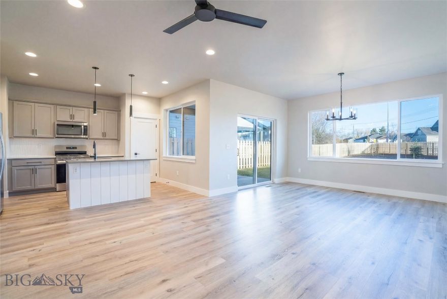 NO CONDO HOA FEES FOR ONE FULL YEAR! This newly built condo is perfectly positioned to take in beautiful views, blending modern design with everyday functionality. The main level features a flexible bedroom and a full bathroom just across the hall, ideal for guests or a home office. The kitchen is outfitted with stainless steel appliances, a gas range, and a stylish tile backsplash, opening seamlessly to the living and dining area. A covered back patio leads to a fully fenced, landscaped yard, perfect for enjoying Montana’s seasons. Upstairs, the spacious primary suite includes a walk-in tile shower, double vanity, and a generous walk-in closet. Two more bedrooms, a full bath, and a cozy nook at the end of the hallway offer added space for work or relaxation. Enjoy morning coffee or evening sunsets on the covered balcony with serene Bridger views.