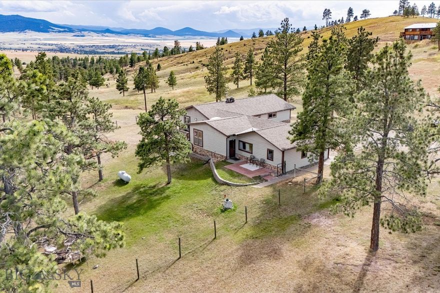 Beautifully Updated 4-Bedroom Home on 5+ Treed Acres with Stunning Views Nestled at the end of the road. This beautifully updated 4-bedroom, 2.5-bath home offers both tranquility and functionality. Enjoy panoramic views from nearly every room—including the dining, living, and expansive wrap-around deck—perfect for outdoor dining or evening BBQs. The heart of the home is a spacious kitchen featuring a large island, solid-surface countertops, and upscale hardwood cabinetry. The adjoining family room and cozy sunroom create the ideal setting for morning coffee or relaxing with guests. Main-level living includes 2 bedrooms, 1.5 baths, laundry, and an attached garage—providing comfort and accessibility. The walkout lower level offers 2 additional bedrooms, a full bath, and a generous family room with ample natural light. A rare find with space, privacy, and views from every direction—this property is a must-see!
