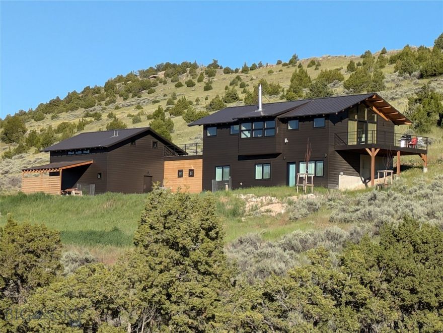 Welcome to Solstice House outside Manhattan, Montana, presented by Blake Maxwell at Skyfarm Design+Build.  With amazing views of buttes and rolling prairie, this architectural home on over 20 acres was designed in the style of Northwest Modernism, popular since the midcentury for its floor-to-ceiling windows, natural materials, clean lines, high livability, and connections to the outdoors.  Built in 2022 and offering 2,705 square feet, the interiors favor coherence and calmness.  Three bedrooms and two baths comprise the ground level, while the pavilion-like upper level presents an open floorplan to engage the landscape.  Two large decks further blur the boundary between living areas and the outdoors.  With horses grazing on a nearby hillside, Big Sky sunsets, and the comfiness of a beach house, it’s a tranquil place where evenings feel like weekends and weekends seem like getaways.  The primary architectural gesture is the alignment of the great room with sunrise on the summer solstice--June 21st this year--giving the house its name (see last photo). In addition, there's an ADU/studio with a separate entrance, kitchenette and ½ bath.  Also, the private well was recorded producing 100 gallons per minute of water, which could easily support a guest house, greenhouse, livestock barn or pasture.  Located on the Gallatin River Ranch, the vast 6,000-acre development is lifestyle-enhancing with two Montana rivers, over 20 miles of private roads great for hiking and biking, and an impressive Equestrian Center.  It's also home to elk, mule deer, pronghorn, coyotes, dozens and dozens of bird species.  Less than three miles from charming Manhattan, Solstice House is a 20-minute drive to BZN airport and 30 minutes to Bozeman’s numerous amenities.