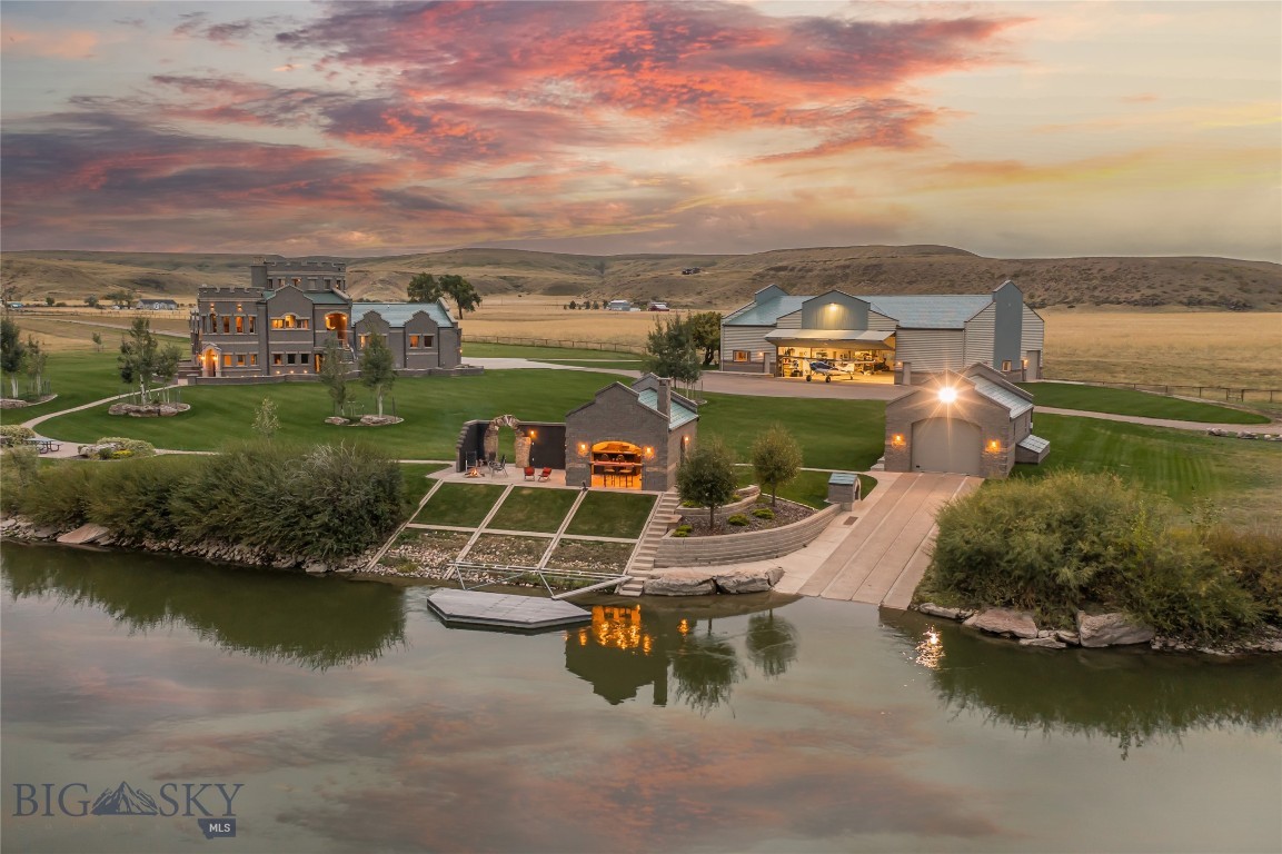Welcome to your own majestic retreat on the banks of the mighty Missouri River! This extraordinary estate offers unparalleled privacy, surrounded by the breathtaking natural beauty of Montana's landscapes. As you approach, you'll be greeted by over a mile of pristine river frontage, providing endless opportunities for fishing, boating, and relaxation along the Missouri. The centerpiece of this remarkable estate is a stunning castle-inspired residence, exuding timeless elegance and architectural grandeur. Features such as a cedar-lined sauna, expansive wine cellar, turret with reading room, two attached garages, multiple fireplaces, and the bold, castle-like courtyard complete with gargoyles, add to the allure of the property. The home is thoughtfully laid out with wings for the homeowners and guests. The main wing includes a bedroom, walk-in closet, ensuite bath, office, laundry room, and one of the attached two-car garages with direct entry. In the guest wing, you’ll find three guest bedrooms, two baths, a 2-car garage, ample storage, and a guest laundry room. The main living area contains a grand entry with vaulted ceiling and an open concept kitchen, living room, and dining room. The exquisite views over the expansive, plush lawn to the river and scenic open lands will take your breath away. Cozy up to the living room fireplace and enjoy the abundance of wild animals and bird life in your backyard. The round dining room has spectacular views in every direction and is highlighted by a custom-made round table to complement the space.
Aviation enthusiasts will be delighted by the inclusion of an airplane hangar and three private airstrips, providing convenient access for travel and exploration. The possibilities are endless for those with a passion for flight and adventure, whether urban or backcountry. For the avid boater or water enthusiast, a remarkable boathouse awaits, complete with a concrete ramp for effortless access to the river. Imagine embarking on leisurely cruises or exciting adventures right from your own backyard. For those seeking space for hobbies or projects, a large workshop within the hangar offers ample room for creativity and craftsmanship, while the two-bedroom guest quarters with a full kitchen provide comfortable accommodations for visitors or extended stays. This exceptional property offers a rare opportunity to own a piece of Montana's pristine wilderness, where every day brings new adventures and cherished memories.