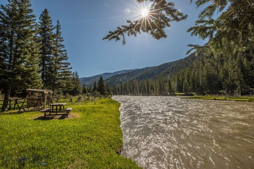 Welcome to Moose Landing—an extraordinary riverside retreat offering unmatched privacy, natural beauty, and timeless design, nestled along 200± feet of the Gallatin River’s most celebrated fishing stretch known as Hog Alley. Located just minutes from the Big Sky Town Center and a short 15± minute drive to world-class skiing at Big Sky Resort, this 3,900 square foot residence is a rare opportunity to own a piece of Montana’s most coveted landscape.

Set on 3.6± wooded acres, the property—known as Moose Landing—offers a serene retreat surrounded by towering pines, open meadows, and abundant wildlife. The home features five spacious bedrooms and multiple living areas designed to host gatherings, create memories, and enjoy the seasons in total comfort.

 

The heart of the home is the expansive main level, where a chef’s kitchen with brand-new granite countertops and high-end appliances opens into a warm, inviting dining and living room space. A wraparound deck offers stunning views over a tranquil pond and the Gallatin National Forest—perfect for sipping coffee at sunrise or enjoying sunset cocktails.

 

Downstairs, find a large recreation space complete with a pool table, poker table, and full bar—an entertainer’s dream. After a day of fly fishing or skiing, unwind in the hot tub or new dry sauna and experience the restorative power of mountain living. A second large living room and four additional bedrooms provide ample space for family and guests.

 

With an attached two-car garage and an additional detached three-car garage, gear and vehicle storage are effortless—whether for fly fishing gear, ski equipment, or summer toys.

 

The property sits at 6,000± feet in elevation on the renowned “Hog Alley” fishing corridor, offering blue-ribbon angling right out your back door. It’s a place where adventure and relaxation meet—whether you're fly casting under blue skies or stargazing beside a fire.

 

48042 Gallatin Road is more than a home. It’s a riverside sanctuary, an amazing place to gather with friends and family, and a rare legacy offering in the heart of Big Sky.