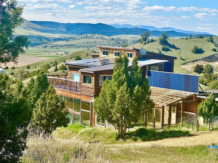 JUST REDUCED - GREAT PRICE for this artistic home on 11 acres with AMAZING VIEWS!!  With SELLER FINANCING CONSIDERED with a minimum of 30% down. If you are looking for a self-sufficient lifestyle, this property is it. Perched on a hill over looking the Clarkston valley, with mountains and the Missouri River as the backdrop - this is Montana off-grid living with big sky views. This imaginative custom home features oversized windows throughout the home frame the beautiful landscape views. The 11 acres are a rustic terrain with character, featuring uniquely shaped Junipers and a level fenced area for livestock. At ~2800sqft, the home has an ensuite master, two additional bedrooms and bath and multiple 'extra' rooms for a studio, office, or family room. There is an additional building beaming with natural light. Animal lovers and those desiring to raise livestock, poultry/game birds - take note - there is a plethora of animal husbandry options with fencing and indoor shelter. Complete off-grid system with solar panels, newer batteries, generator, cisterns, invertors and three propane tanks convey. This property is ~ 1/2 mile off the County-maintained road and school bus route. The west side of the Clarkston community borders public land and the Missouri River. The local towns of Manhattan and Three Forks are ~25 miles and Bozeman is ~45 miles.
