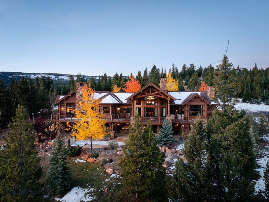 168 Charlie Russell is an exquisitely artisan-crafted, hand-hewn log estate located within the gated enclave of Big EZ Estates, offering the opportunity to obtain a golf or ski/social membership at Spanish Peaks Mountain Club. Set on 20 private acres, this extraordinary 7,000± SF Montana legacy home captures sweeping views of Yellowstone National Park and the Spanish Peaks, with unforgettable sunrises, moonrises, and sunsets.

The residence features 5 bedrooms, 5 full baths, and 2 powder rooms, along with six interior fireplaces, an outdoor fireplace, fire pit, and new hot tub for year-round enjoyment. Four private primary suites, each with its own fireplace, outdoor access, and individual thermostats, providing exceptional comfort and privacy. A charming timber-frame bunk room includes an en-suite bath.

The main level showcases soaring ceilings, a dramatic floor-to-ceiling stone fireplace, expansive living and dining areas, and an entertaining gourmet kitchen with premium appliances and generous prep space. An executive office with private deck access is conveniently located off the great room and primary suite. The primary suite offers a spa-like bath, walk-in closet, and private deck.

The lower level is designed for recreation, featuring a spacious family room, wet bar, pool table, additional fireplace, and direct access to the hot tub and fire pit. Outdoor living is enhanced by a wrap-around deck, multiple patios, and peaceful mountain vistas.

With 20 acres of usable land, room for future improvements, exceptional privacy, and close proximity to Big Sky’s world-class amenities, this property captures the essence of the Big EZ lifestyle—a rare and timeless Montana retreat.