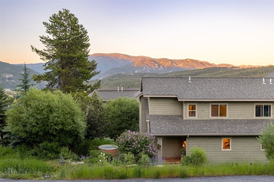 Nestled in the hills, this charming Deer Run hideaway is conveniently located within walking distance to an array of Big Sky Town Center amenities. The lovely end unit enjoys an updated open kitchen-dining-living room with cathedral ceilings and wood burning fireplace, 4 bedrooms, 3 full bathrooms, and an attached 1 car garage with extra parking in front. Uniquely located at the end of the street with mature trees, which provide screening, privacy and space! Enjoy a generous side yard, a rarity in the neighborhood, offering a beautifully landscaped area with dry stacked stone walls, a sitting area, rose & lilac bushes, hot tub and organic herb garden. Two decks provide enough space to accommodate a BBQ and seating area. Recently updated finishes include elegant quartz countertops in a neutral palette along with new flooring and new carpet. Moen plumbing fixtures exude casual elegance & highlight flawless hickory cabinetry throughout. Natural sunlight illuminates generously sized windows, with mountain and tree views. Attributes include ample storage, generously sized master walk in closet, Ring security cameras and alarm system, Honeywell programmable thermostats, garage opener and heated hobbyist garage with burly work bench, ideal for ski and snowboard tuning, complete with sturdy overhead shelving. Great central location in Big Sky, within walking distance to summer farmers markets and outdoor concerts, grocery stores, bank, retail shopping, art galleries, restaurants/bars, theatre, BASE community center, free shuttle to skiing at Big Sky Resort and nearby hiking/biking/Nordic ski trails - but tucked away for privacy & the escape of road noise. Your private Big Sky getaway retreat for family and friends - or investment opportunity awaits! Selling fully furnished, turn-key, minus personal exclusions. Seller will pay one year of HOA dues at closing as an added bonus for the Buyer!