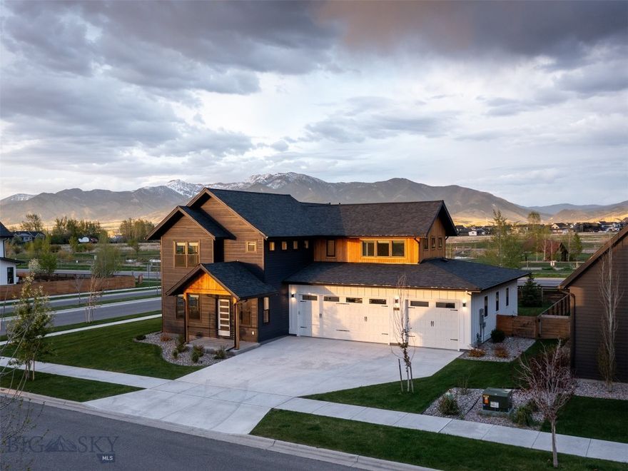 Modern farmhouse luxury meets an unparalleled park-side location in Flanders Mill. Featuring panoramic Bridger Mountain views and a highly functional floorplan, this like-new Bozeman home is the perfect fit for spacious living. Located across from the 100-acre county park and with up to six bedrooms—or the option for custom bonus and office spaces—the layout offers rare flexibility to suit your lifestyle. Enjoy high-end finishes including central A/C, luxury window treatments (many motorized) and lighting, engineered oak wood flooring on main, stairs and upstairs landing, tile flooring in baths, quartz counters, laminate cabinetry, and upgraded internet networking. The vaulted great room features a living room with excellent natural lights and mountain views, a cozy gas fireplace, ample dining space and a chef’s kitchen. Watching the ever-changing Montana skies through the plentiful windows will be your new favorite pastime in this home. The kitchen features quartz counters, laminate cabinetry, tile backsplash with under cabinet lighting, a large pantry, dining bar and stainless appliances including gas range with exterior vented hood. Double sliding doors open from the living room to the covered back patio – making for perfect indoor-outdoor living. The peaceful, main-level primary suite features patio and hot tub access, a large walk-in closet and a luxurious primary bath with soaking tub, quartz twin sink, twin head tile surround shower and toilet room. A second junior suite bedroom or corner office on main shares access to a ¾ bath with tile shower. Upstairs features three more large bedrooms and a fourth bedroom or bonus room with excellent natural light. The upstairs hall bath features quartz counters, twin sinks and separate tub and toilet area. Laundry on main doubles as a mud room – featuring plentiful storage – the washer/dryer convey. Enjoy the fully fenced and landscaped backyard with an extra-large patio and upgraded hot tub. A 3-car, 921 sq ft attached garage features extra deep shop space and is finished and heated – perfect for storing all your Montana adventure gear. Convenient location features easy amenity to miles of trails and area parks. Just minutes to shopping, grocery, restaurants, medical services, and Montana State University. 10 minutes to historic downtown Bozeman, 30 mins to Bridger Bowl, 15 mins to blue ribbon fly-fishing and river recreation, 55 min to Big Sky. Don’t miss the 360 3D Matterport Tour!