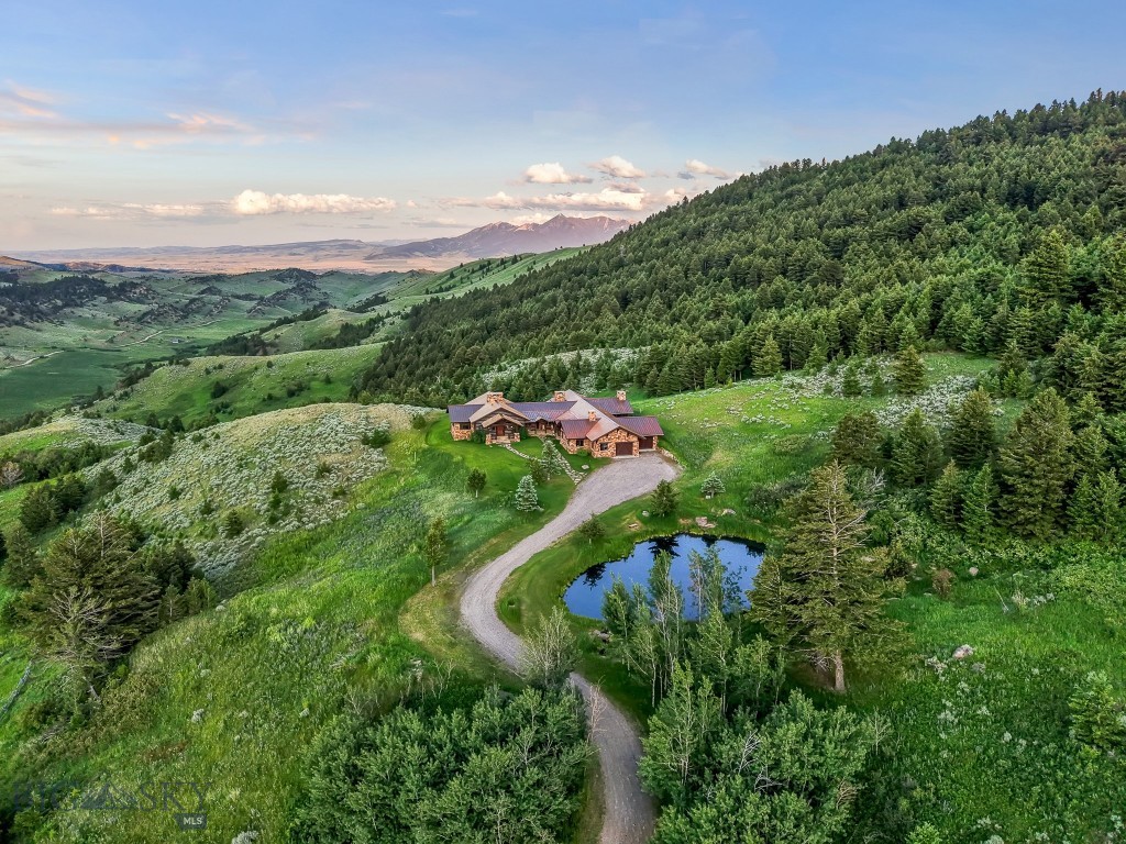 Sky Band Ranch, at the southern base of the Bangtail Mountains captures the magic of Southwestern Montana. Its location between the treasured towns of Bozeman and Livingston makes it even more desirable. The ranch spans +/- 262 serene acres offering the freedom to mountain bike, hike, horseback ride, hunt, snowshoe or cross-country ski right out the back door. It supports horses or other livestock. Area Creek (also known as O’Rea Creek) runs on the ranch for approximately 1/3 mile. The gorgeous western-style residence and pond are tucked upon a hilltop bordered by timbered hillsides, lush meadows and creek bottom providing refuge to elk, deer, moose, bear, grouse, Hungarian partridge, and other impressive wildlife. The residence built in 2008 exemplifies exceptional craftsmanship and meticulous attention to detail, effortlessly combining rustic style with attractive finishes perfectly integrated into the striking Montana landscape. Massive amounts of stone were brought in for the outdoor patio area, some interior and exterior walls, and five substantial fireplaces. Hewn Douglas fir was used for the interior and exterior walls. Custom made cabinetry, solid wood doors, trim and gorgeous wide plank fir flooring which has been recently refinished to perfection are found throughout the main floor. Pella windows and French doors frame the beautiful landscape of mostly ranch land with the Absaroka Mountains as its backdrop. Massive wood beams/trusses and impressive two-sided stone fireplace anchor the sun filled open floor plan of the living/kitchen/dining area creating a wonderful lodge atmosphere for gatherings or hunkering down with an enjoyable book. Additionally, there is a dedicated office/library, a spacious laundry room, and an oversized attached two-car garage. Downstairs is a 4,758 sf partially finished walk out basement offering endless possibilities. Excellent candidate for a conservation easement. Sky Band Ranch offers an extraordinary Montana lifestyle for outdoor enthusiasts seeking stunning views, open space and nature near world-class amenities.