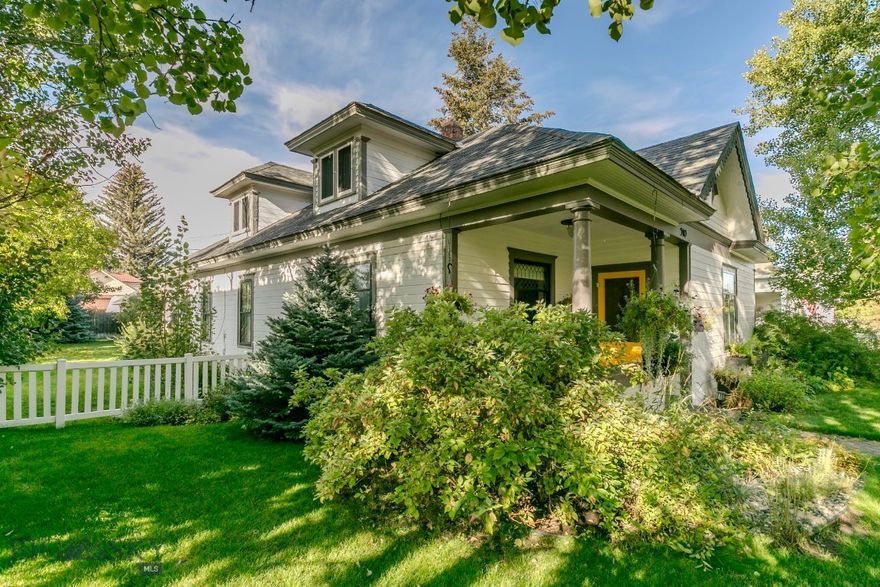 The Yellow Door Bungalow! Timeless charm in the heart of Big Timber! This beautifully cared-for 1904 home offers vintage character with modern comfort, featuring original oak hardwood floors, classic pocket doors, bright welcoming rooms, and a covered front porch with standout curb appeal. The landscaped yard includes mature shade trees, colorful flower beds, and a classic white picket fence—enhanced by a seasonal shared well for convenient irrigation. A detached garage with workshop, alley access, and great storage complete this picture-perfect in-town property.