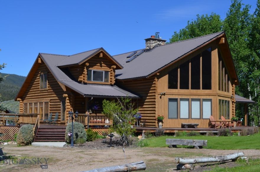 Experience the beauty of Montana, living on this remarkable 30 plus acres in Grasshopper Valley, completed with endless recreational amenities.  This stunning 5312 sq.ft. log home boast breathtaking views in every direction. Step inside to find thoughtfully designed layout, a tile entry that leads you into the oversized living room with floor to ceiling windows and a striking river rock massive fireplace that served as a focal point in this living space.  A formal dining room with laminate flooring leads to the library room for a cozy sitting area.  A well thought out kitchen has lots of work areas, awesome views of Maverick Mountain Ski Area, a large walk in pantry, a prep sink, kitchen appliances and a working wood cook stove sits in the corner.  The sunroom is a favorite room to take in all the sun, great for plants , morning coffee, and additional room for entertaining ,plus a 3/4 bath across the hallway.  Upstairs you will find the whole area as a Master Suite, that overlooks the living room. Master bath with jacuzzi tub, walk in shower, oversized walk in closet and dual sinks.  The other two rooms have historically used as an office, exercise room or craft area.  The basement conveys a game room with pool table, wood stove, mechanical room with storage, a full bath, two guest bedrooms (egress) and a family room with a walk out covered patio area. Outside you'll find spacious three car finished garage with a versatile finished room upstairs, ideal for a workshop, office,  or dorm area for guests. An RV garage provides ample storage for all your outdoor adventure gear along with your RV or other vehicles. Stay warm during the colder months with a 7 zoned boiler heating system, the river rock fireplace and the wood stove in the basement. Other outbuildings include the wood storage building, small shed and screened in building that you can enjoy the soothing sounds of Dingley Creek flowing though the property.  Surrounding by mature trees and showcasing stunning views, this property is a true haven for nature lovers and outdoor enthusiasts alike.  With the perfect blend of comfort functionality and natural beauty, this exceptional retreat is ready to be your Montana Dream Home.