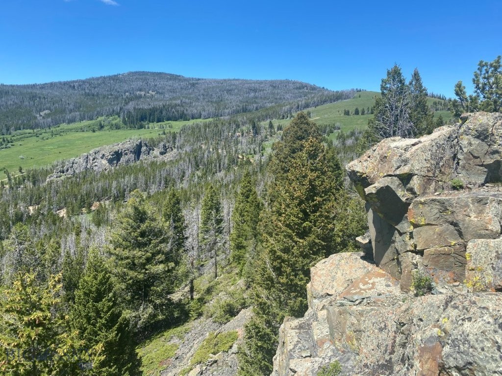 This great 18 acres of land actually borders National Forest land on the Helena National Forest. I say actually because it’s extremely rare to find land like this out in the Elkhorn Mountains that borders the National Forest. The Elkhorns are a highly sought-after mountain range because of their big elk and lots of elk. This is one of those unique opportunities to own land in the Elkhorn Mountains that you’ll look back on for decades to come and be glad you seized the opportunity to buy this property. The elk get so big here, and they’re so well-known because the bull tags are on a limited draw, and they’re hard to get. This allows the age structure to be higher, the bulls to be bigger, and there can be more of them than on regular public land. That’s all part of what makes the shed hunting in the spring so good, too. The property not only borders the National Forest but you’re way out in the National Forest so you can just take off in literally any direction and have tens of thousands of acres of National Forest lands to hunt, hike, and recreate on. There’s a system of roads throughout the Elkhorns for driving and ATVing and trails to hike that provide for lots and lots of access and opportunities. The Elkhorn Mountains are so picturesque with their rolling topography and open parks framed by all their expanses of forested hillsides. There are fantastic views of the Elkhorns and that’s not to mention the distant mountain peaks of other Montana mountain ranges like the Bridger Mountains and the Tobacco Root Mountains. There’s an amazing elevated building and camping site that’s already been leveled in the trees with rock formations right behind it, and a really old relic car body left right where it quit chugging decades ago, that makes this site extremely unique. It’s ready to build that cabin in the mountains you always dreamed of. You can point those picture windows in the direction of the views. Or you can simply pull in your camper and enjoy the weekends and your new Montana mountain property instantly. The property is accessible by Forest Service roads in the summer and fall, and the roads are gated and closed to motorized use from December 2nd to May 15th every year to keep from disturbing critical wildlife winter range. Service controlled gate sits about 3 miles further down the Indian Creek drainage. That’s close enough you could certainly hike, snowshoe, or ski in to visit your cabin and enjoy the solitude during the winter months.