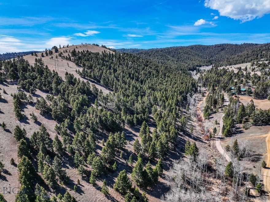 Located minutes from Ramsay and Butte, this 83.02± acre property in Silver Bow County offers privacy, year-round access, and direct boundary with Deer Lodge National Forest. Accessed via Lone Pine Gulch Road, the property features a level build site tucked among fir and aspen trees with power nearby. It is well suited for a home or cabin in a private, scenic setting.

From the lower bench, the land rises through mature timber into open ridges with diverse terrain and outstanding views. Elevated portions capture sweeping vistas of the Highlands, surrounding mountains, nearby valleys, and the Butte area. About half the acreage is timbered with mature fir and aspen, while the balance is open ground suited for recreation or livestock use.

A spring runs through the lower draw and may provide a seasonal water source depending on annual conditions. Combined with varied terrain, cover, and forage, the property offers strong wildlife habitat. Deer and elk are known to frequent the land and adjoining public ground, making it attractive for hunting or wildlife viewing.

One of the most valuable features is direct access into Deer Lodge National Forest. From your own property, you can ride horseback, hike, or hunt onto public land without needing to trailer or seek additional access.

The surrounding area offers outstanding year-round recreation. Fairmont Hot Springs features geothermal pools and golf, Discovery Ski Area provides winter sports, and Georgetown Lake is popular for boating, fishing, and ice fishing. Extensive nearby public lands create endless opportunities for trail riding, hiking, and exploring.

With no covenants, a ready-to-build homesite, diverse topography, wildlife, and close proximity to Butte, this property presents an exceptional opportunity to create a Montana residence, retreat, or recreational basecamp.