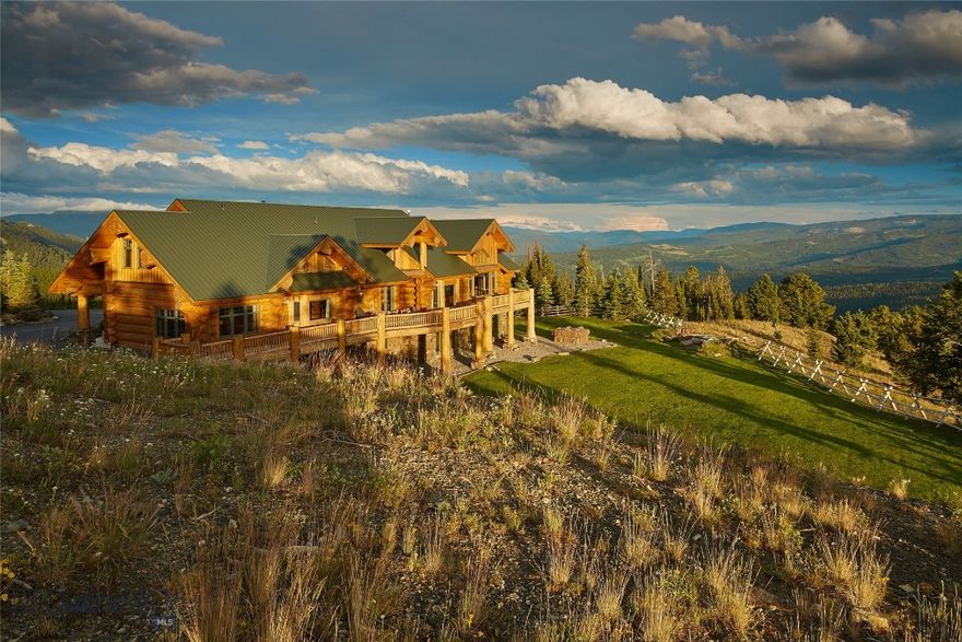 A once-in-a-lifetime opportunity in the heart of Big Sky, this 491-acre private retreat is unmatched in scale, beauty, and location. This land is a rare blend of history and wilderness; early 1900s logging roads wind throughout, creating year-round access across the property for hiking, horseback riding, mountain biking, ATVs, or snowmobiles. In winter, it transforms into a private Nordic haven with miles of groomed cross-country ski trails just outside your door.
Surrounded on three sides by Gallatin National Forest and conserved properties, the estate offers the kind of permanent privacy and protection that is nearly impossible to replicate. Wildlife is abundant, with elk, moose, deer, bears, mountain lions and bobcats often wandering through. Despite its seclusion, this property is only minutes from Big Sky’s world-class skiing, dining, and amenities.
Perched on a ridgeline, the magnificent Canadian cedar log home was designed to frame Lone Peak from every west-facing room. The architecture balances strength and warmth, with soaring timbers, natural stone, and walls of glass that bring the mountains in. A full-length entertainment deck stretches across the western side of the home, perfectly positioned for Montana’s legendary sunsets and panoramic views. From this vantage point, the sightlines are unrivaled: Lone Peak, the Madison Range, the Spanish Peaks, the Gallatin Range, and even south into Yellowstone National Park.
A detached garage with a fully appointed caretaker’s quarters above provides both practicality and flexibility, whether for staff, guests, or private office space. Together, the structures combine modern livability with timeless craftsmanship, set against one of the most dramatic backdrops in the Rockies.
The location offers the best of all worlds—absolute privacy yet total convenience. Big Sky Resort is just 10 minutes away, as are the Meadow Village and Town Center. Bozeman lies an hour north, and Yellowstone National Park is just over an hour to the south.
This spectacular property is truly one of a kind—an irreplaceable Montana legacy, offering unmatched seclusion, beauty, and convenience in one of the West’s most iconic landscapes.