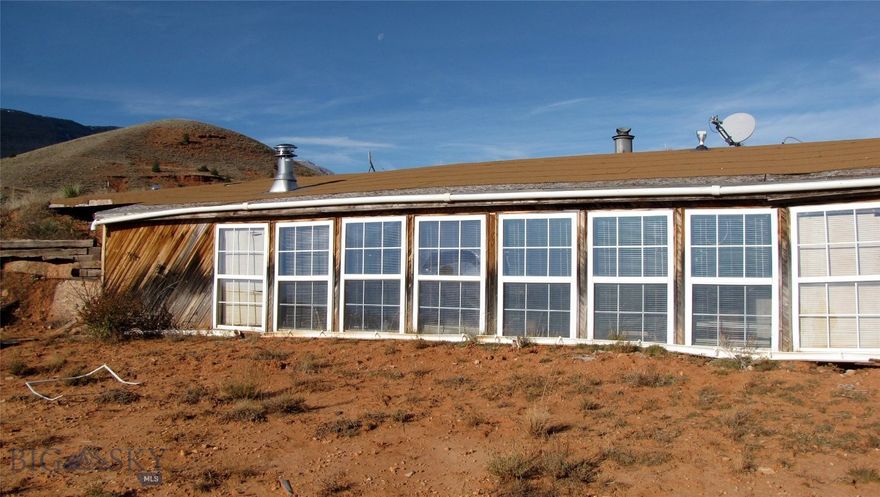 Are you dreaming of remote living far from bright lights and city crowds? This old cabin on 20 acres at the foot of the Pryor Mountains, miles from power and people, may fit the bill. It offers spectacular views of the east face of the Pryor Mountains that loom above you, with the Bighorn Mountains to the east and the rugged Bighorn Canyon in-between. No one lives within 20 miles of this property, only antelope, sage grouse, mule deer, wild horses, Bighorn sheep and elk on occasion. There is a 1600+ sq. foot “earthship” cabin, built in 2007 (2 bedrooms, 1.5 baths) that is in poor shape and will need significant repairs. It has not been lived in for over 5 years and has suffered greatly (see photos). Original owner reported it has a septic, but no permit is on file. Propane and wood for heat and cooking, with a well that is reported to have 1/2 gallon per minute. There is also a 400 sq. foot barn, corral area & pump house for well. It is fenced on the east side of county road. Cell phone coverage is spotty; internet would need to be by satellite. Transmission power lines run along the eastern edge of the property, but there are no nearby power lines that one could hook into. This property is remote, offering one an opportunity to escape the city lights and have a secluded cabin with spectacular views in an area seldom visited by others. Year-round access to the property with a 4x4 would be possible, but may require some snowplowing in the winter. This land is only a mile from the Bighorn Canyon National Recreation area, a treasure of public land in your backyard known for its wild horses, 1000 foot cliffs and canyons, and miles of water for boating. Lovell, Wyoming (pop 2400) is 30 miles to the south for shopping needs, while Cody (pop 10,000) is 75 miles away and has a commercial airport. The largest city in the area is Billings, Montana, which is 125 miles to the north via Lovell and Bridger, MT. With about 120,000 people Billings offers all major retail outlets, excellent regional medical facilities, as well as an International Airport. The owner will finance with at least 10% down. 20 acres a half mile to the north is also available for $69,500.  Call for details.
