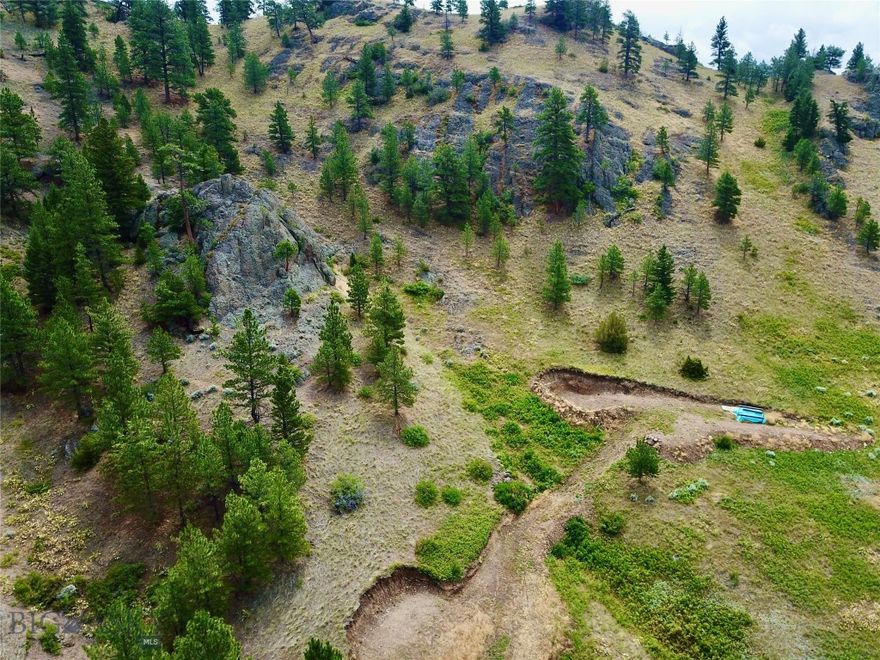 Where the Dearborn River cuts a path alongside the majestic Adel Mountains, this 15.34-acre parcel offers peace, privacy, and a true connection to nature. Here, wildflowers dot the landscape with bursts of color, while towering mountains and dense forest set the scene for a life immersed in Montana's rugged beauty. Several flat building sites have already been excavated, ready for your dream home, cabin, or shop. From this elevated perch, take in panoramic views of the Dearborn River winding through the distance. Wildlife is abundant—watch for bobcats, moose, bighorn sheep, mule deer, and white-tailed deer as they pass through the property. Let the sounds of nature envelop you: birdsong in the morning, the wind through the trees, and the occasional call of an eagle soaring overhead. Hike to the flat-topped high point on the property for even more expansive views—perfect for relaxing, reflecting, or simply taking in the unmatched sights of Big Sky Country. Adding to its appeal, a 135-square-foot off-grid utility building is already in place, thoughtfully equipped to support a comfortable, self-sufficient lifestyle. Inside, you’ll find an instant water heater, propane heater, solar inverters, solar batteries, a generator for reliable power, and sleeping quarters in the loft! Solar panels capture Montana’s abundant sunshine, while a propane tank and dual water tanks provide essential resources. A water pump and filtration system ensure clean, accessible water, and a sink, Flame King propane stovetop, and off-grid fridge/freezer allow for modern conveniences in this remote retreat. Whether you envision a base camp, weekend getaway, or a permanent off-grid residence, this property is ready to bring your Montana dream to life.