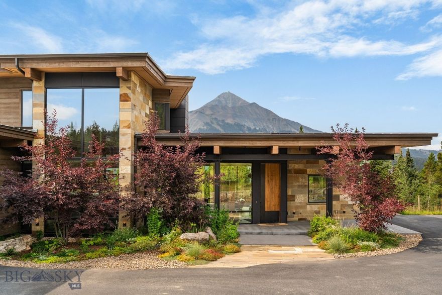 10 Middle Rider Road offers direct ski access, commanding mountain views, and a thoughtfully crafted mountain modern home built in 2018 by Big Sky Build. Positioned to capture sweeping vistas of Lone Mountain, Fan Mountain, and Andesite Ridge, this one-owner residence reflects a high level of care, intention, and quality throughout every phase of construction and design.
Ski directly from the property to Big Sky Resort, enjoying seamless access to some of the best skiing in the country. The exterior blends wood, steel beams, and stone to create a timeless mountain modern aesthetic that feels both refined and durable.
Inside, the home features five bedrooms, four full bathrooms, and two powder rooms. The main living area is a true centerpiece, showcasing dramatic 13-foot ceilings and expansive 11-foot-tall windows spanning the full width of the room, flooding the space with natural light and framing the surrounding mountain views. A custom steel staircase with floating wood treads adds architectural impact and elevates the interior design.
The kitchen is both stylish and highly functional, equipped with a Bosch induction cooktop, integrated wine refrigerator, and a walk-in pantry with ample counter space for additional appliances. The home also offers a formal dining area along with a cozy breakfast nook, each positioned to take full advantage of the scenery.
Comfort is prioritized with radiant in-floor heating, forced air for quick comfort, motorized shades, and Lutron lighting for intuitive and efficient control throughout the home. Outdoor living is equally inviting, with a covered porch and integrated gas fire pit—ideal for relaxing after a day on the slopes.
The primary suite occupies the upper level as a private retreat, featuring its own dedicated porch, nearly 270-degree views, a wall of windows, and wood-beamed ceilings. The spa-inspired primary bathroom includes a soaking tub with views, quartzite countertops with custom matching sinks, a private makeup vanity, under-cabinet lighting, and a walk-in closet with custom built-ins.
The lower level offers an additional living room and workout area, providing flexible space for recreation, fitness, and movie nights. 
With direct ski access, exceptional views, and a home defined by craftsmanship and intention, 10 Middle Rider Road represents Big Sky mountain living at its best.