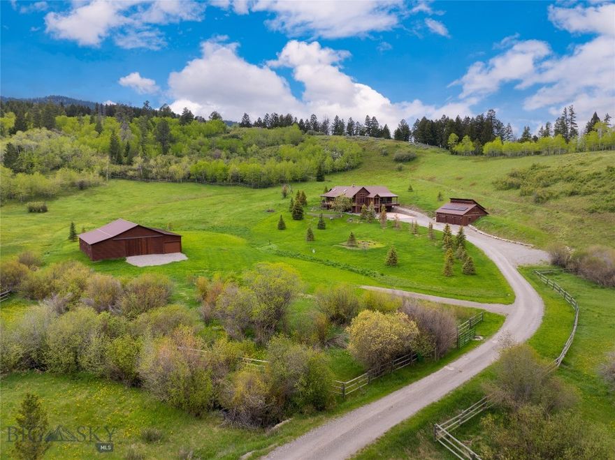 This mountain modern masterpiece know as 3011 Goose Creek is nothing short of spectacular! Nestled into the verdant landscape of Bozeman, Montana's Gallatin mountain range, this legacy property boasts rolling meadows, forests and groves, and year-round live water. Visiting deer, moose, fox and Sandhill Cranes are a regular occurrence. This expansive 6,989+/- SF home has been beautifully updated and perfectly balances modern luxury and Montana warmth in a breathtaking setting. One is welcomed into the main level of the home by the majestic great room with a contemporary rock fireplace and custom wood flooring present throughout. The gourmet kitchen is elevated by Bosch stainless steel appliances, custom cabinetry, solid surface counters, and boasts a huge dining area with a cozy family room with wood stove. French doors access the spacious deck that overlooks Goose Creek and the incredible barn. The private primary suite is beautifully appointed and features a separate large room awaiting custom finishings as a walk-in wardrobe/dressing room. The elegant bath features a soaker tub, double vanity and walk-in shower. The main level also features a gorgeous guest quarters with its own private entrance, offering a bedroom, full bathroom, dramatic vaulted living room, kitchen, and laundry room—perfect for visitors or multi-generational living. The upper level includes two bedrooms and a full bathroom. The lower garden level features two generous bedrooms, two full bathrooms, an office, a flex space and a laundry room. The home also provides the convenience of an oversized attached 2-car garage with enormous storage, while a detached 3-car garage/shop includes a loft area ready for inspiration from a new owner.
The barn is a showstopper with polished concrete floors and an impressive lighting and overhead door package, ideal for multiple uses like entertaining, car collection, or the most stunning horse barn around! Ideally situated near Forest Service access via Goose Creek Road, the property offers endless opportunity for the outdoor enthusiast. While only 15 minutes to Main Street Bozeman, this unique offering is provides a quick escape
to a serene rural Montana existence. Enjoy the ultimate Montana lifestyle at 3011 Goose Creek, where privacy, luxury, and nature come together seamlessly.