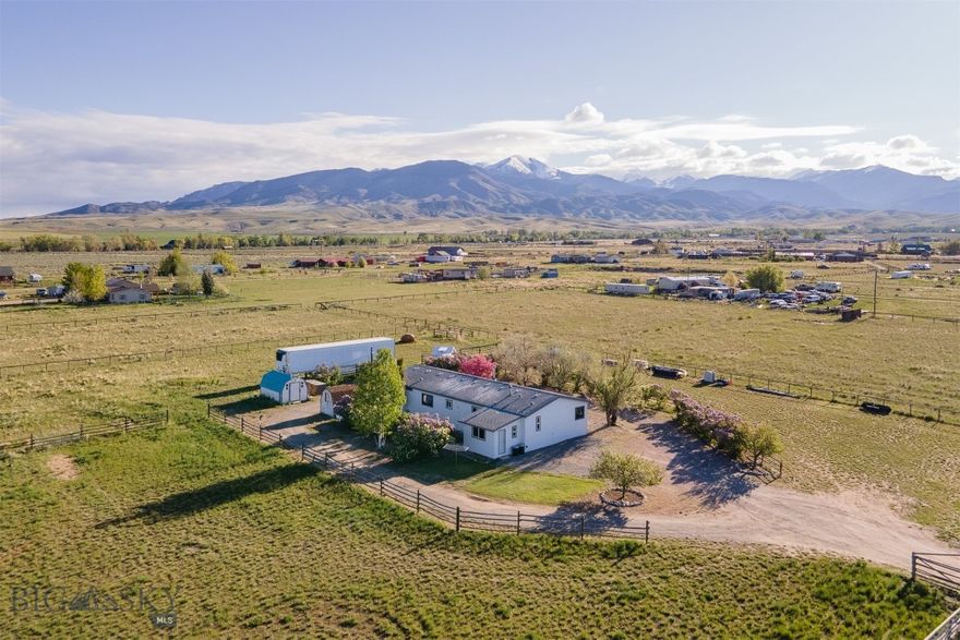 Experience the ideal balance of privacy, space, and peaceful rural living at 150 Tuke Lane, perfectly situated between Twin Bridges and Sheridan. This thoughtfully maintained and tastefully updated 4-bed, 2-bath manufactured home sits on nearly 2 acres of usable land, surrounded by mature landscaping featuring apple trees, lilacs, and a picturesque fenced entry. Offering 1,848± sqft of living space, the open floor plan highlights a spacious master suite with walk-in closet and ensuite bath, while three additional bedrooms positioned at the opposite end of the home provide quiet separation and versatility. The comfortable living room features a wood-burning stove and large windows to bring in ample natural light. The updated kitchen with pantry includes new countertops, refrigerator, and dishwasher, flowing seamlessly into a dining area perfect for meals and entertaining. A flexible space adjacent to the kitchen and living area is ideal for a home office, hobby room, or playroom. From the laundry room, equipped with a new washer and dryer, step into a generous mudroom offering storage and a dedicated space for organizing outdoor gear or hobbies. Fresh paint, new carpeting & LVT flooring, and newer windows throughout enhance the bright and inviting interior. Enjoy year-round comfort with forced air heat and central AC. Outside, relax on the expansive deck complete with a hot tub hookup, an ideal spot to unwind while taking in mountain and valley views. Two storage sheds come with the property, providing convenient extra space for tools, equipment, and gear. Cross-fenced into three pastures with no covenants, this property is perfect for gardening, animals, or simply enjoying the beauty of country living. Don’t miss the opportunity to make this exceptional Montana property your own, schedule a showing today!