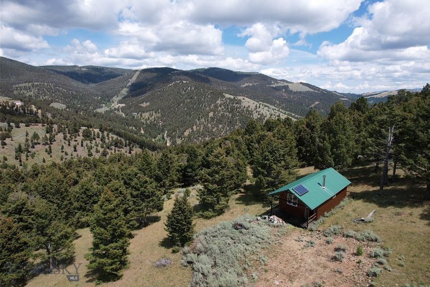 Quaint, off-grid mountain cabin located in the Boulder Mountains of Southwest Montana. The cabin features a functional and rustic interior with a maintenance free and fire-resistant exterior. Complete with a wood stove and a basic solar system for lights and necessities. The property is on just over 30 acres made up of two parcels with mixed terrain and borders public lands for hunting and recreation. The access is good but limited in the winter months. About 30 minutes to the town of Boulder, MT and 1 hour to Helena or Butte, MT.  Elk, deer, and moose call this place home. Enjoy year-round recreation from this property, hunting, hiking, ATV trails and more!  Come soak in the solitude of this remote property in Southwest Montana! Live your adventure!