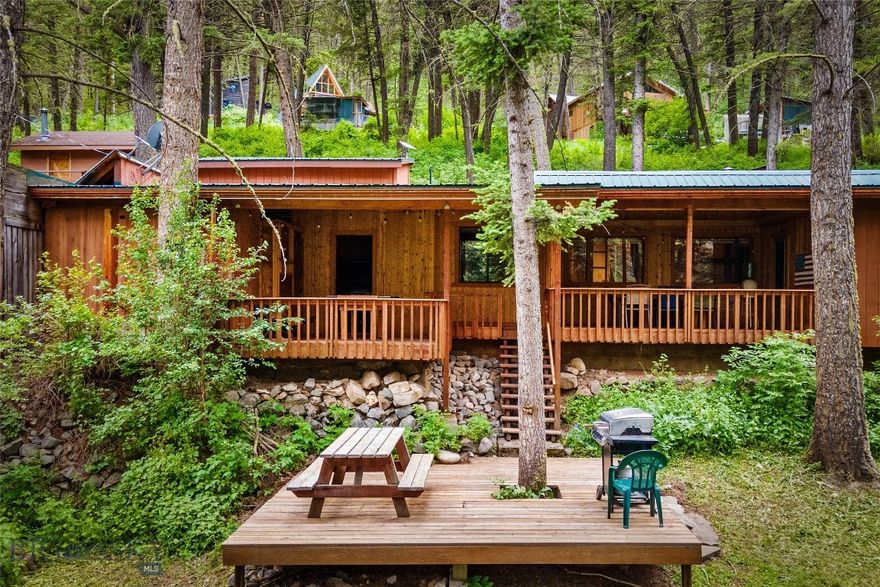 If you're looking for a quintessential Montana adventure, then THIS is YOUR property. Tucked into a piney hillside, across the road from the Gallatin River and just beyond the shadow of Storm Castle Peak, this location is spectacular: Big Sky is 25 minutes up the canyon, and Bozeman is 35 minutes to the north. Plus the Gallatin National Forest pretty much surrounds the place with its endless miles of hiking trails, mountain lakes to explore, fishing, rafting, and more. Here's the basic info on the buildings: MAIN HOME: 3 bedrooms, 2 baths, kitchen, dining area, cozy living room with wood burning stove, and lots of deck and patio space. CABIN: 1 bed, 1 bath, kitchen, equally cozy living room with wood stove, loft for extra sleeping space, and wrap around deck. BUNK HOUSE: 2 bunk beds, a fridge, wood stove, and small deck. What it lacks in water (there's none, so no bathroom) it makes up for it with historic charm. DETACHED GARAGE: 2 doors, one tall RV door, plenty of storage space and an unfinished loft above. This would make the perfect gathering place for family & friends, or a great vacation rental. There's lots to unpack and the description & photos can only do so much, so call for your private tour. You'll fall in love once you see it in person. This property is also listed in the Multi-family category as MLS#403230