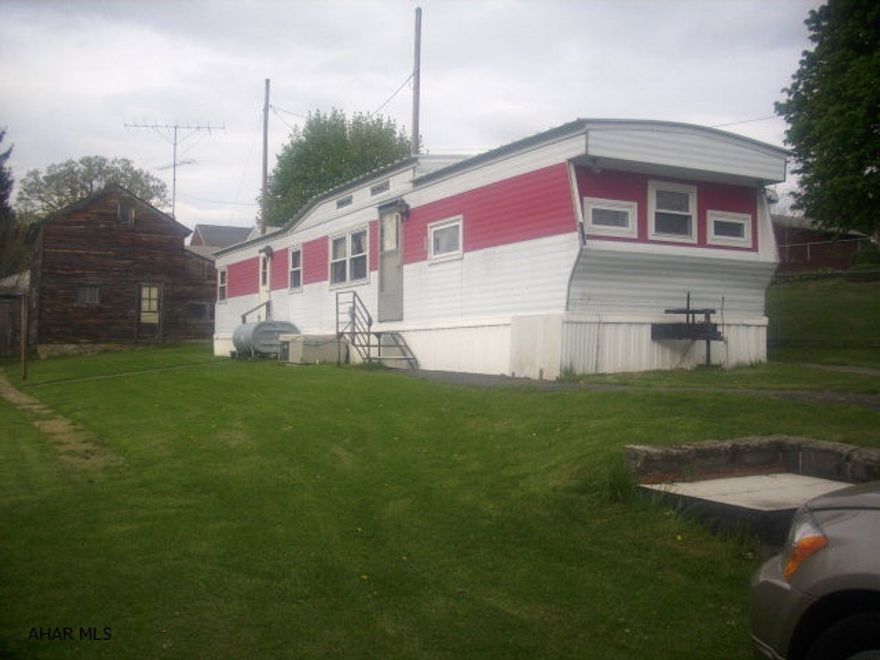 Well maintained 1977 12x60 Holly Park mobile home on 0.172 acre. New windows--double hung, double pane with screens. Public sewer, private well that's only 4 yrs old. 2 bedrooms, 1 full bath. All appliances included along with kitchen table and chairs. Central air. 1 car detached garage in front, large outbuilding in rear. Paved drive in front and paved alley in rear of property for additional access. A lot of property at a great price!