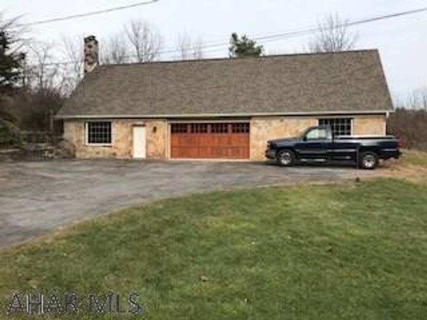 Unique property presently used as a rental.  Raised ranch style home on 1.10 ac.  Updated living space with a gorgeous stone fireplace.  Access to living area is from the rear only, garage and storage space at ground level.  Plus Large Detached garage. Enjoy the privacy and wildlife in your back yard.  Don't wait.