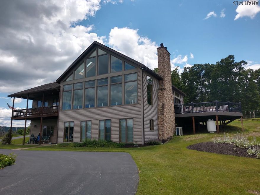 This is a unique & rare property!  87 acres with an elegant contemporary home & panoramic views.  Floor plan is creative.  You enter into a foyer w/half bath.  To the left is the great room with LR w/stone gas fireplace, vaulted ceiling of oak w/beams, kitchen, DR & doors to new deck. Right side is Master BR w/skylights & open jacuzzi and bath, his/her shower & vanity, WIC.  Lower level has FR w/stone wall & gas fireplace, carpet, lighted tray ceiling.  Also 2 BR's, full bath, 2nd kitchen, laundry/utility. Hugh 48x30 three-car garage w 8' doors,12x30 workshop, 16x30 office area to right - has 3/4 bath - can also be mother-in-law suite, business. Covered front porch w/patio underneath.  Circular paved driveway w/pond in center. Garden & orchard.  Includes 2 additional acres w/separate deed.