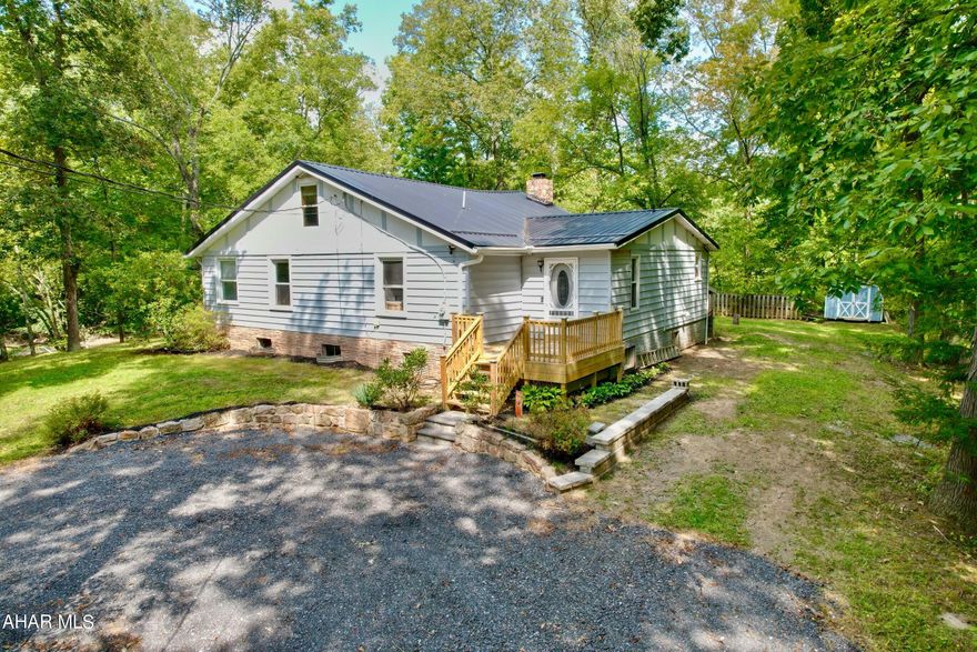Sit on the deck, listen to the water flow down the river, watch the wild life drink from the stream, or fish off the land from this cabin in the woods.  This private setting is on Dunnings Creek with 1.5 acres.  It has 4 bedrooms with a bonus loft.  The open floor plan is great for entertaining or family gatherings.  This home has plenty of room for all your guests and includes remodeled bathrooms, kitchen, flooring, furnace, and so much more.  There is space for everyone indoors and outdoors. This can be used as a vacation rental or a full time residence.  There are so many possibilities! Close to Blue Knob State Park, Shawnee State Park, I99, Rt 56, PA Turnpike