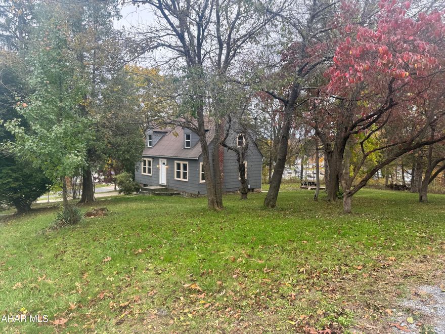 This charming 3-bedroom, 2-bath home offers an extraordinary opportunity on a spacious 0.65-acre lot, providing a rare blend of privacy and unbeatable convenience as it sits directly in Penn State Altoona campus's backyard. Imagine the ease of walking to classes or work via the private path directly behind the property, all while enjoying a serene setting surrounded by mature trees. Inside, you'll find great potential, including two large upstairs bedrooms with multiple closets, and recent upgrades like new stairs off the back deck. While the property needs TLC, its prime location and generous lot size make it an ideal candidate for both a rewarding forever home project or a highly sought-after rental investment in the competitive Altoona market.