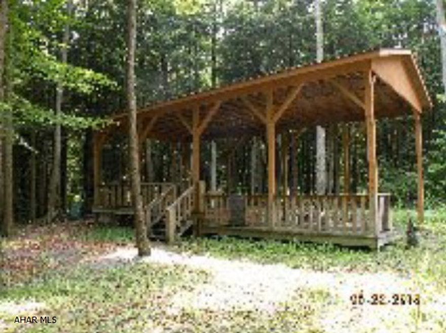 Full pavilion with 12 x 16 shed. Will accomadate a 44 ft motor home or a 5th wheel. Electric to pavillion & shed.  Super lot with stream & open ground behind property. Looking at offers