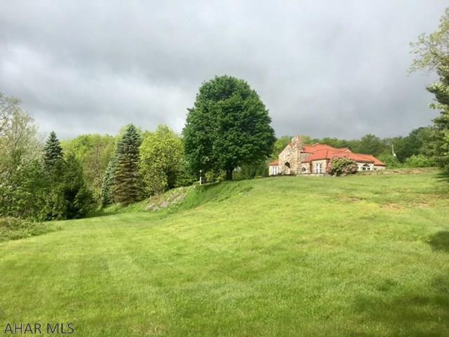 This 1930's mountain retreat is a stone 4 bedroom, 2 bath home with mostly original features and 2450 square feet. Additionally there is a 2 bedroom, 1 bath carriage house with a 3 bay garage, pub with all utilities and a wet bar. The design of the home was inspired by John Lochrie (original builder and currently owned by the Lochrie family) and similar to homes in his native Scotland. The stone on the house is from a nearby quarry with an original  clay tile roof. The house was designed with a driveway around the house to prevent trees overhanging the house and so the sun would warm the walls and roof!  The walls are double thickness!  Sitting at 2900', the views are unmatchable for our area!  The house is surrounded by State Game Lands and there is an additional 188 acres available.