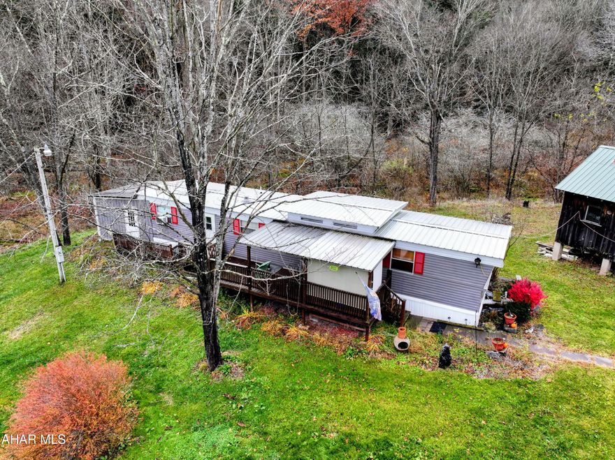 Escape to your own private mountain retreat! This beautifully renovated Mobile Home combines rustic charm with modern comfort, offering a peaceful getaway in an unmatched location. This tranquil home on a secluded rented lot is perfect for nature lovers, outdoorsmen, or anyone seeking a low-maintenance escape in the woods. A hot tub room addition provides the ultimate space to unwind after a day of hiking or skiing, the spacious deck is ideal for morning coffee or summer night conversations.  Nestled on a quiet, secluded lot that borders Blue Knob State Park and State Game Lands 26, and just minutes to Blue Knob All Seasons Resort for skiing, golf, and hiking.  This property offers a rare opportunity to own an affordable retreat in one of Pennsylvania's most scenic mountain regions. Whether used as a weekend getaway, hunting cabin, or peaceful year-round residence, this home delivers the perfect blend of comfort, charm, location, and affordability!